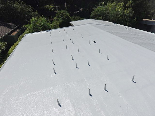 Commercial corrugated metal roof cleaned and primed for spray foam roofing system