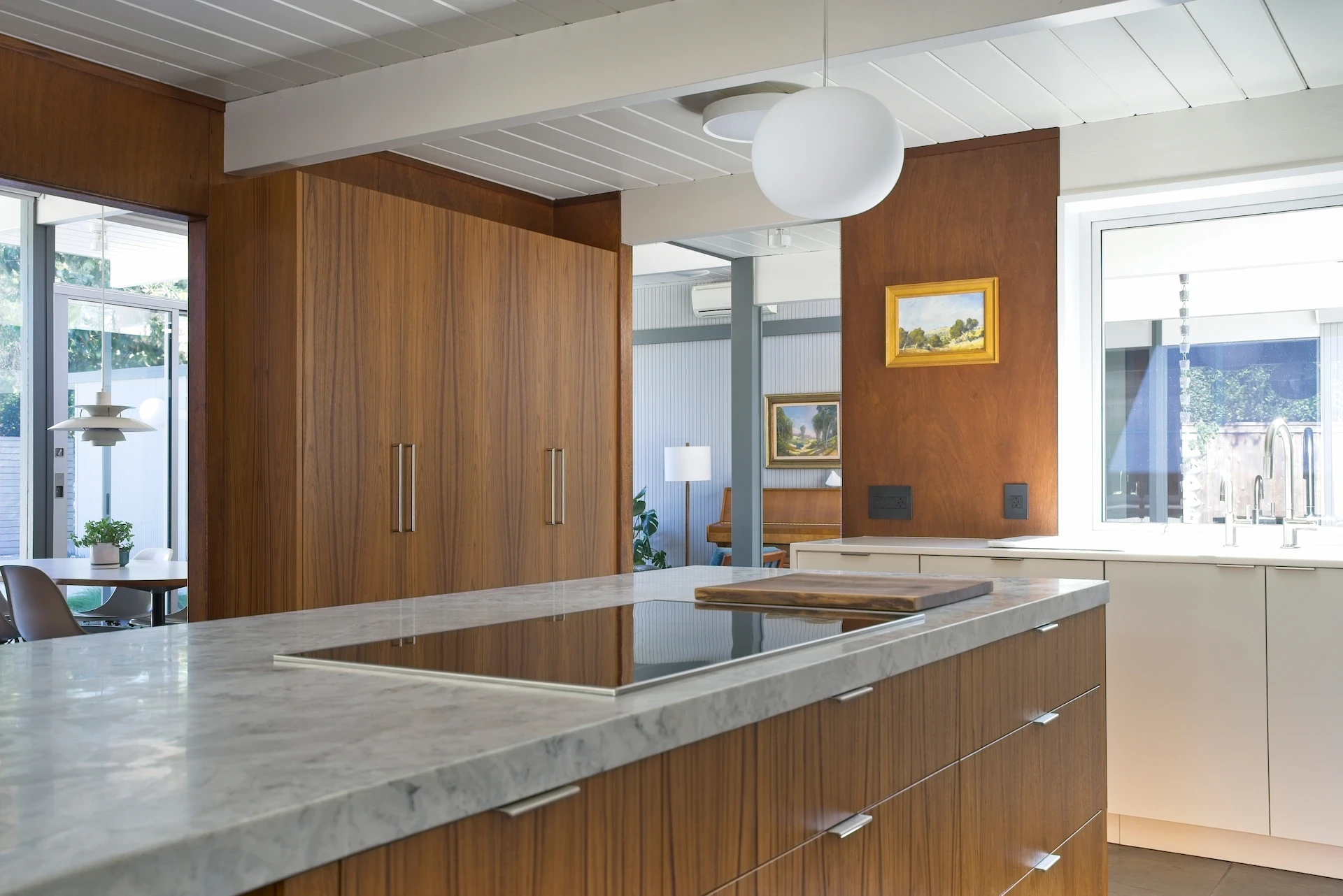 Wide view of the kitchen island at an angle, displaying the exquisite quartzite surface and custom cabinetry in the Eichler kitchen remodel. Photo by Todd Huge.