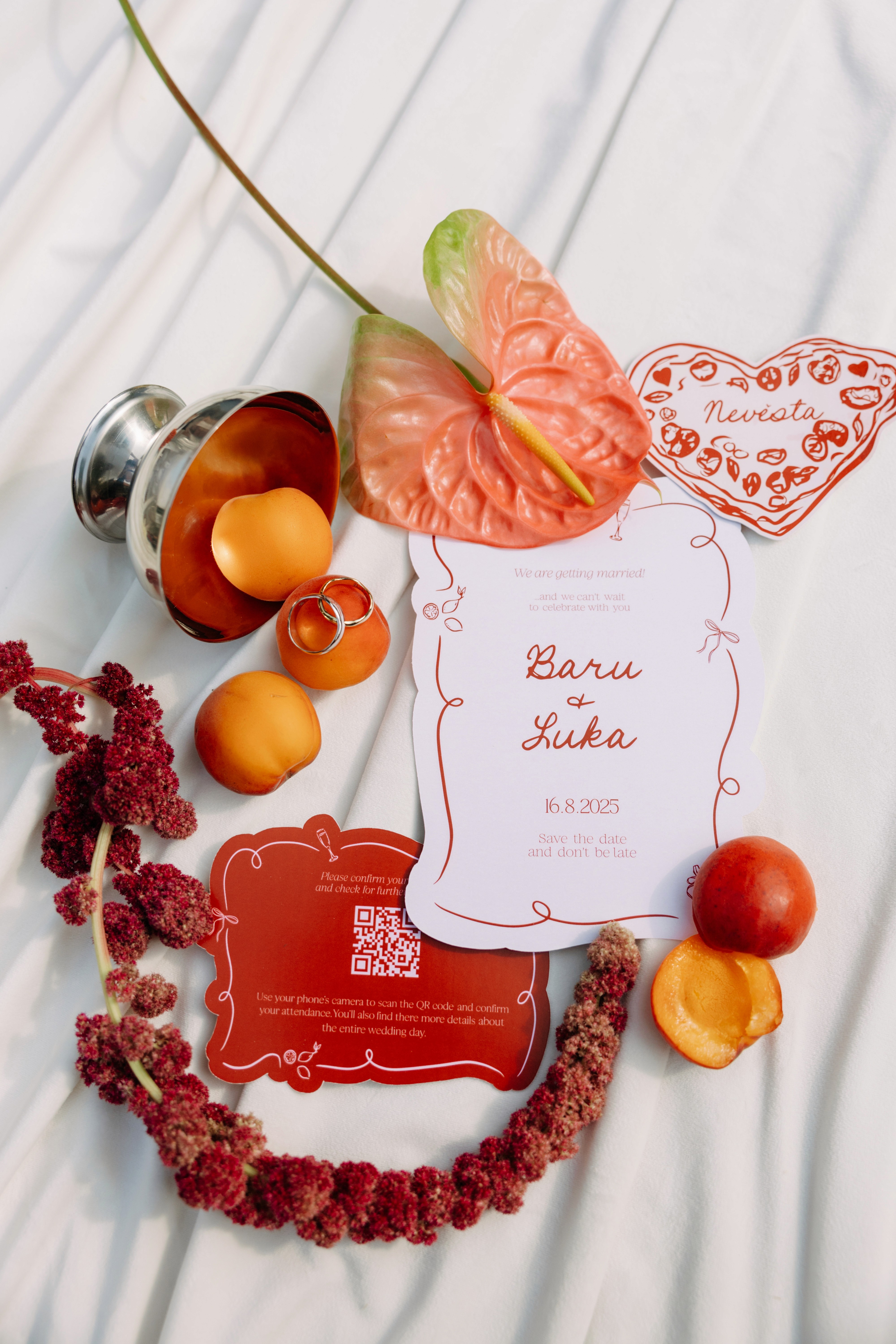 Detailed flat-lay of wedding stationery styled with fruits and flowers — tactile, rich, intentional.