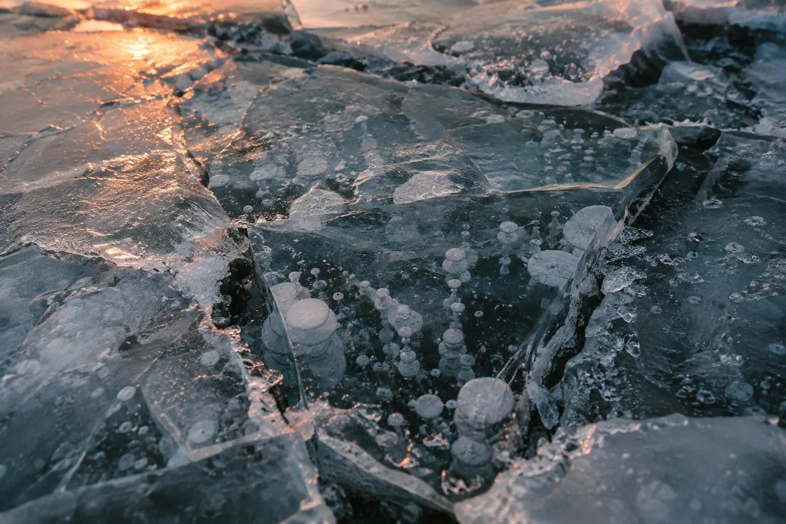 Close-up of cracked ice plates with frozen air bubbles.