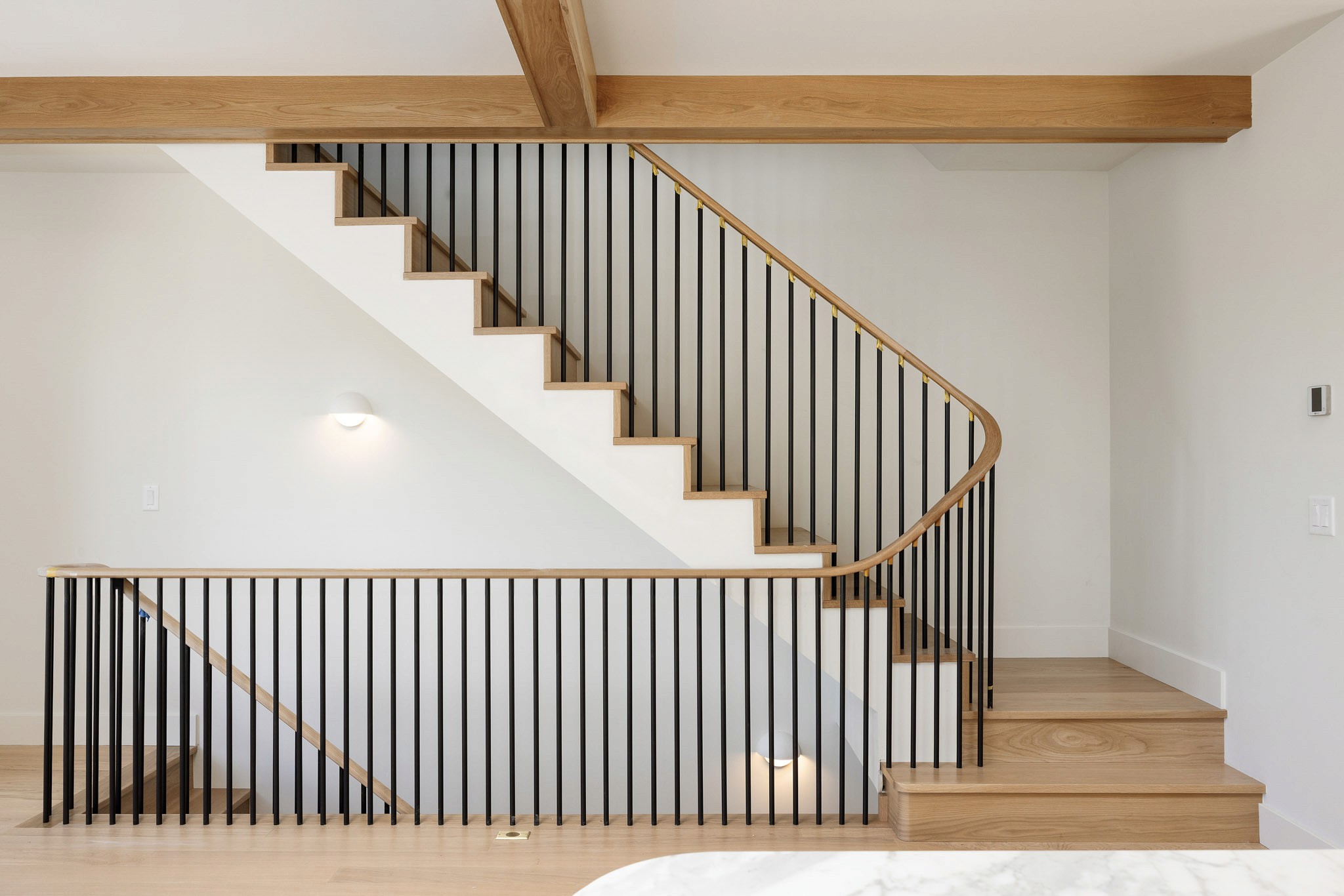 Staircase with wood treads and vertical spindle railing at the Brownstones at 100 Park