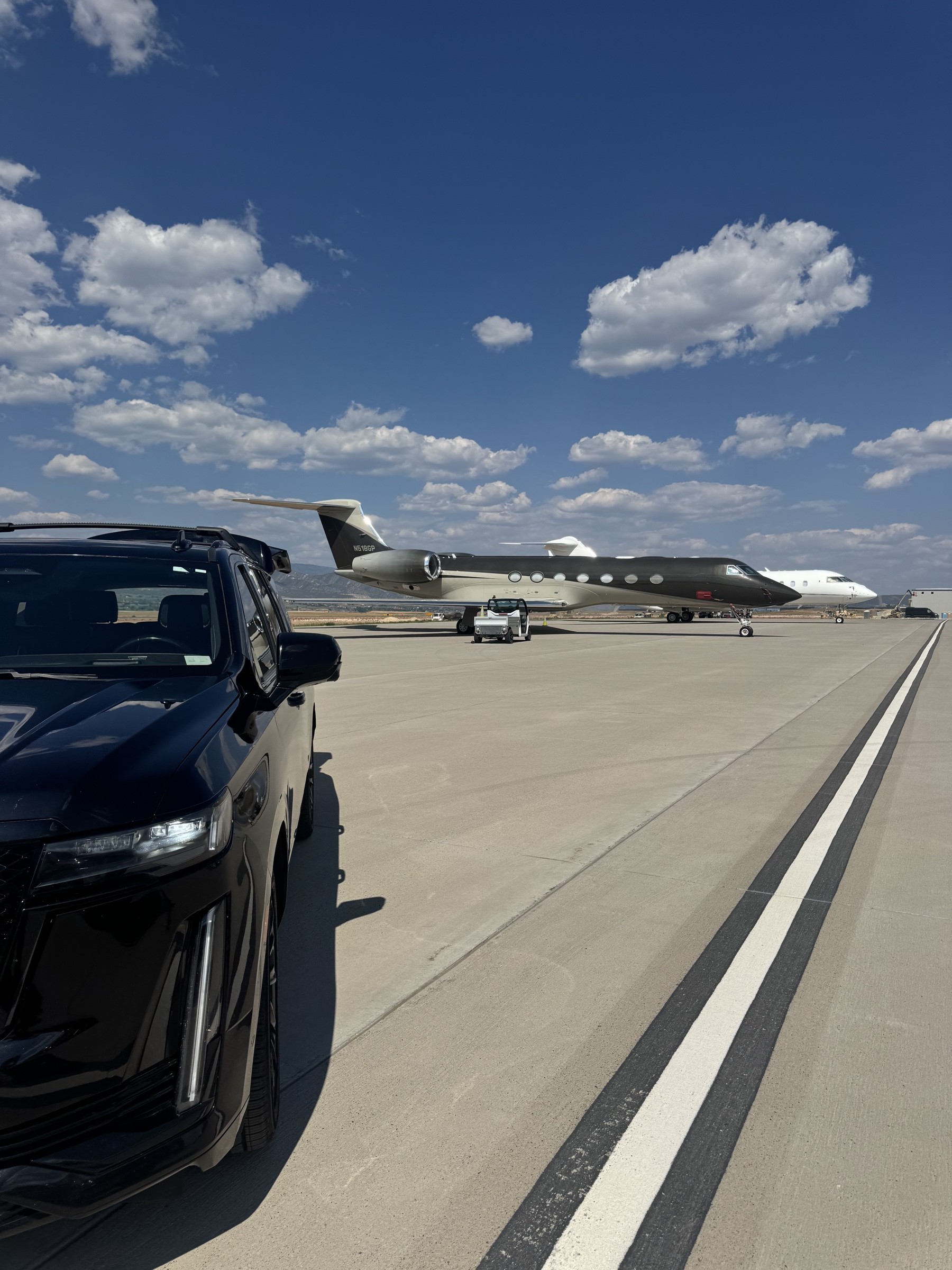 Cameron James Group SUV planeside on the FBO ramp beside a Gulfstream