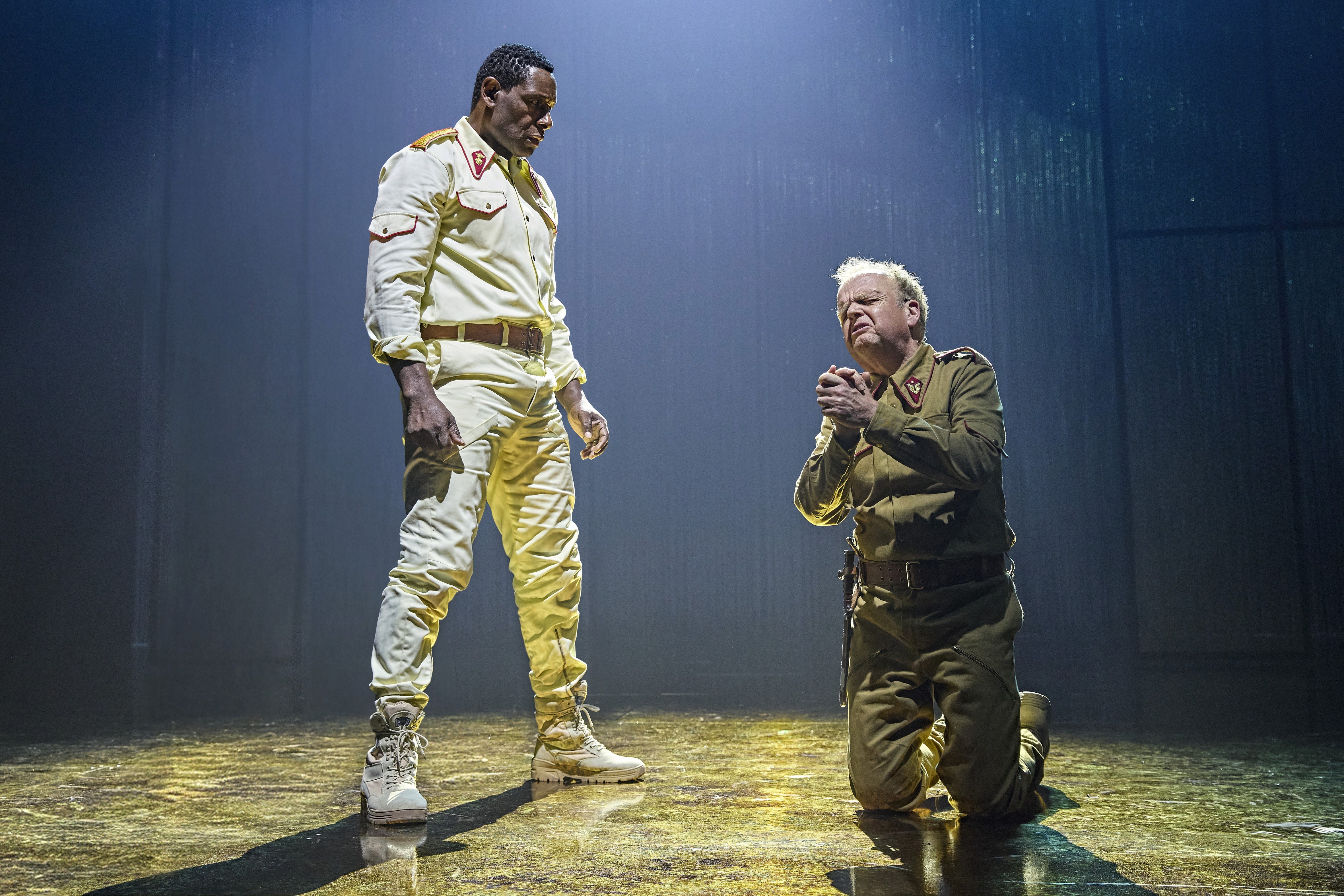 Othello West End confrontation with a soldier kneeling before Othello onstage.