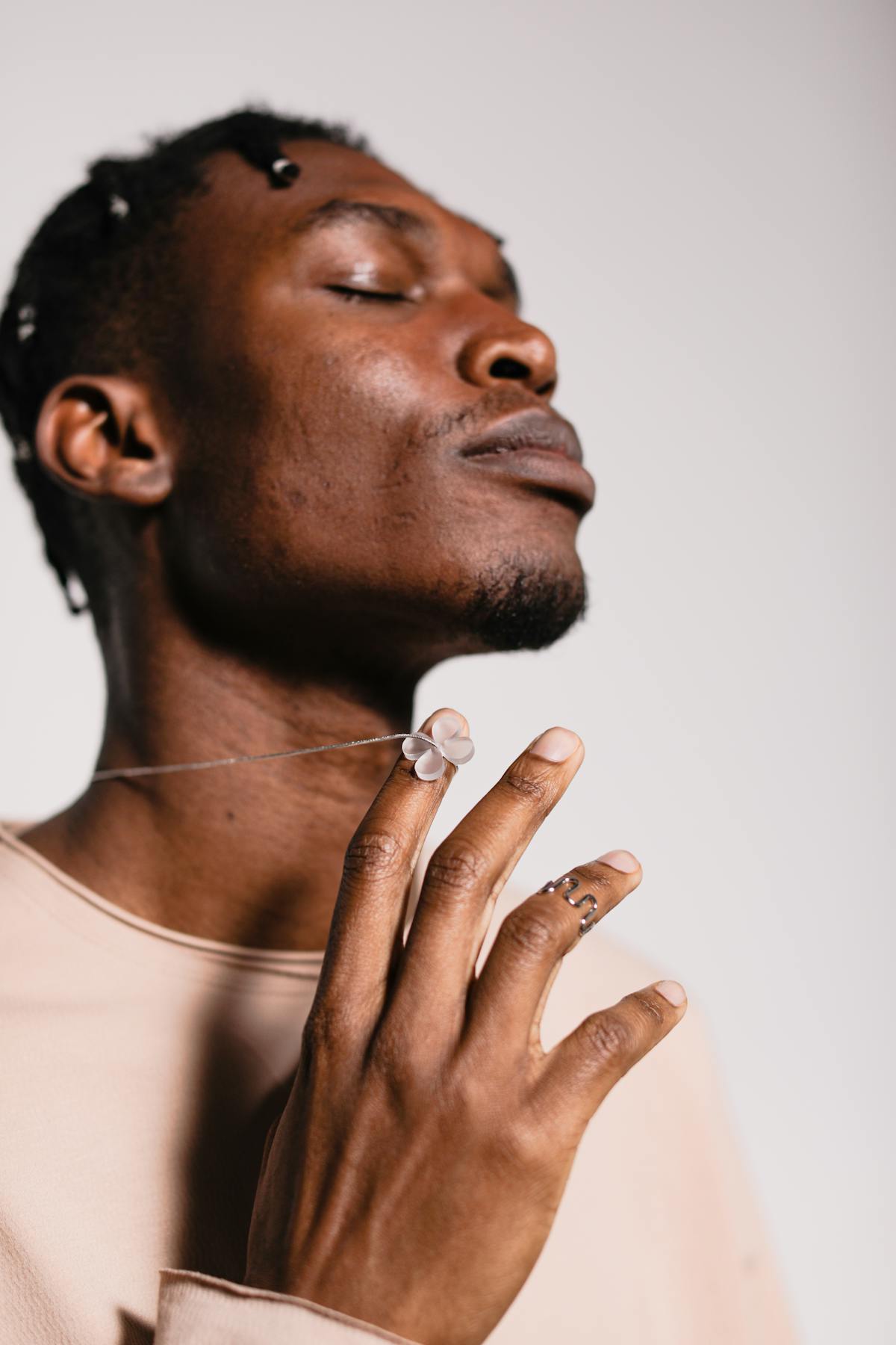 Side profile of a man playing with his necklace