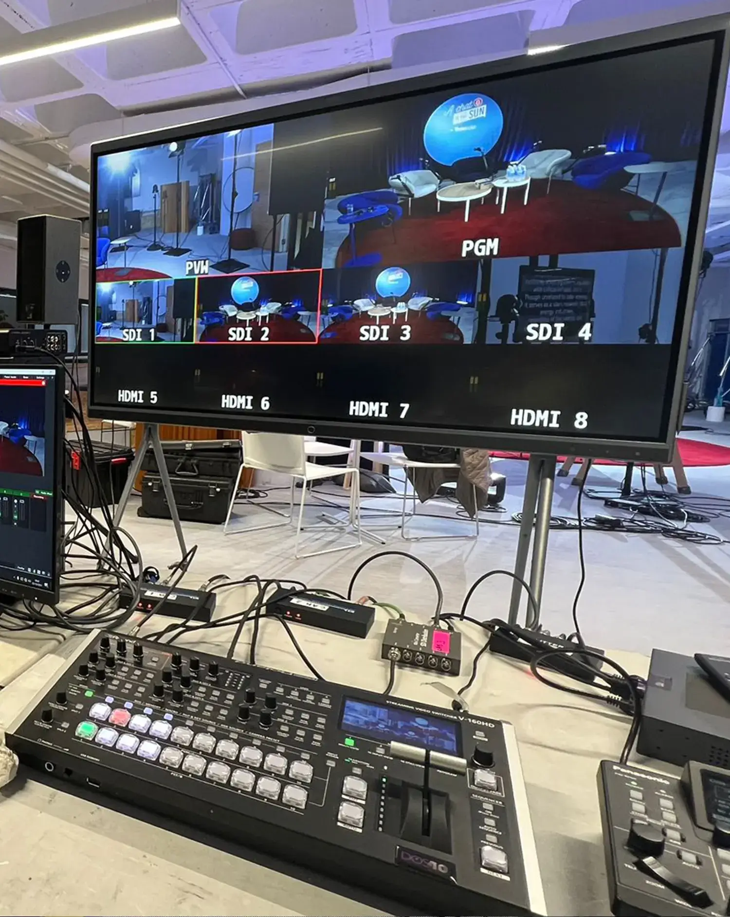 Estudio de producción audiovisual con equipo de control de video y pantallas múltiples.