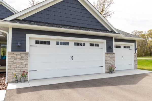 new three stall garage with stone and blue siding