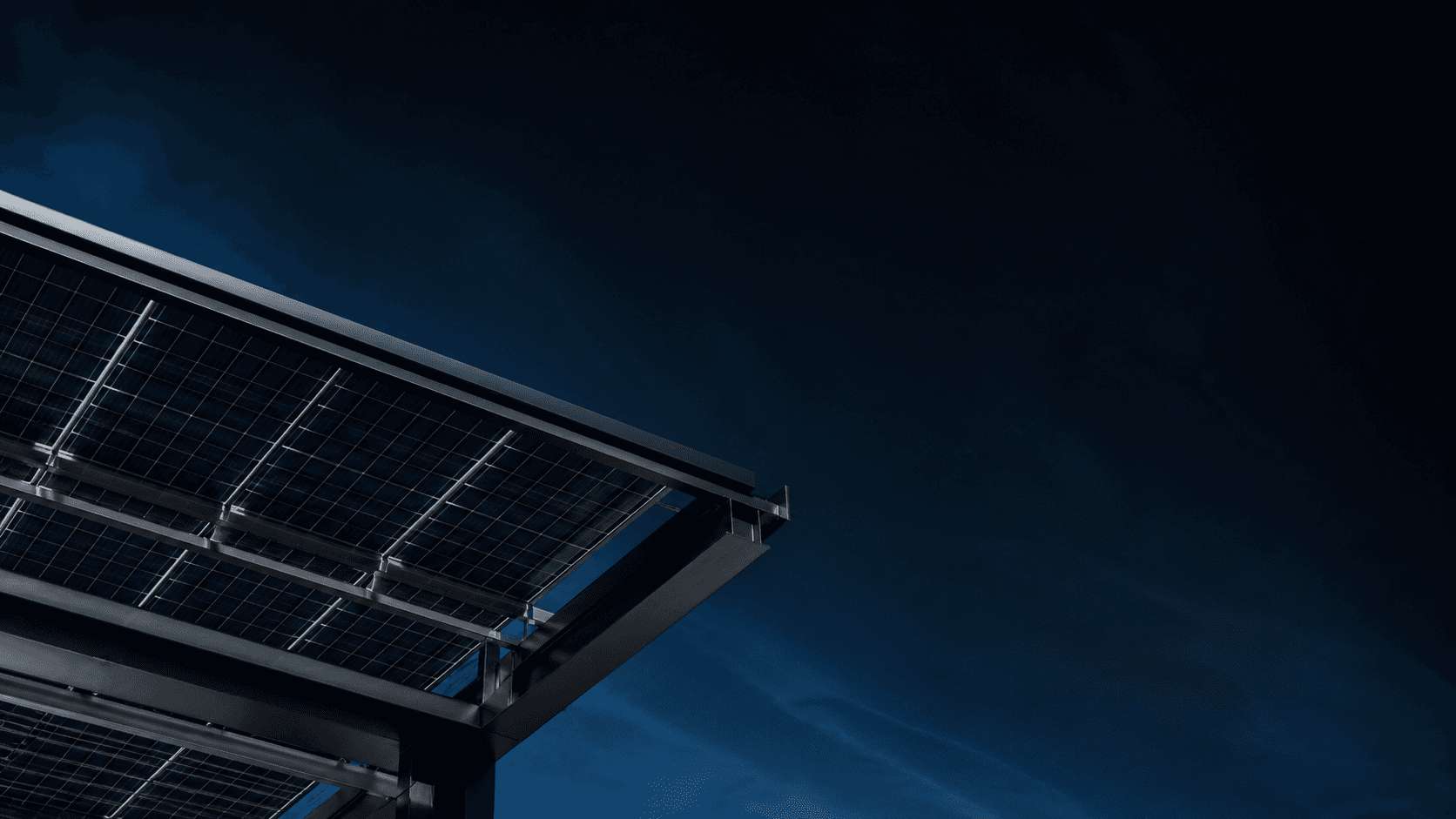Structure d’ombrière solaire vue par dessous dans un ciel bleu nuit