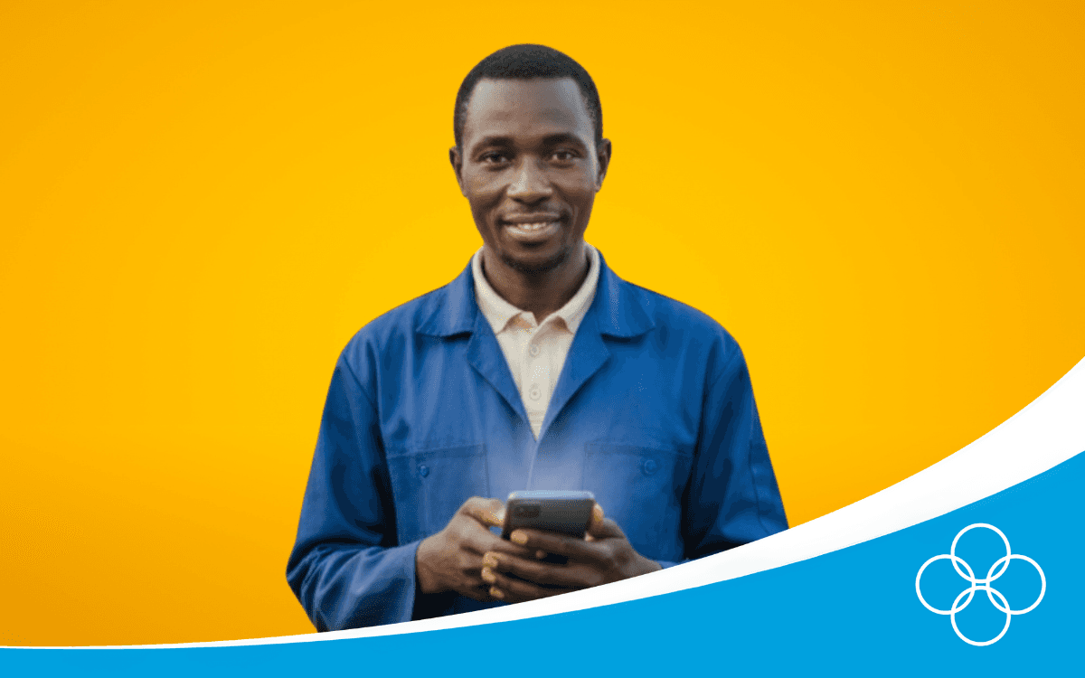 Poultry farmer in a blue overall with a phone in his hand with 123POULTRY app on his screen