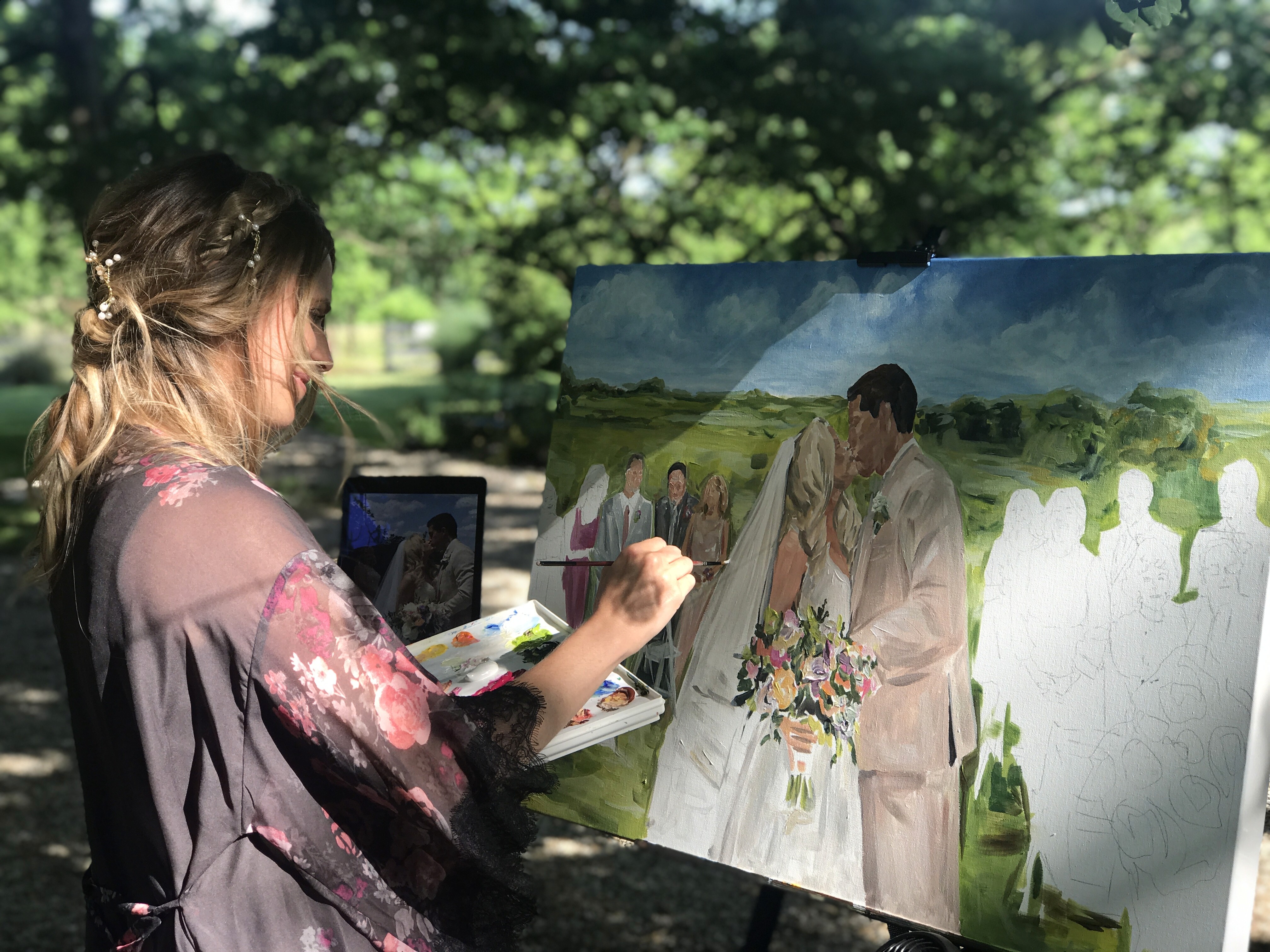 Heather painting a wedding portrait on a large canvas outside