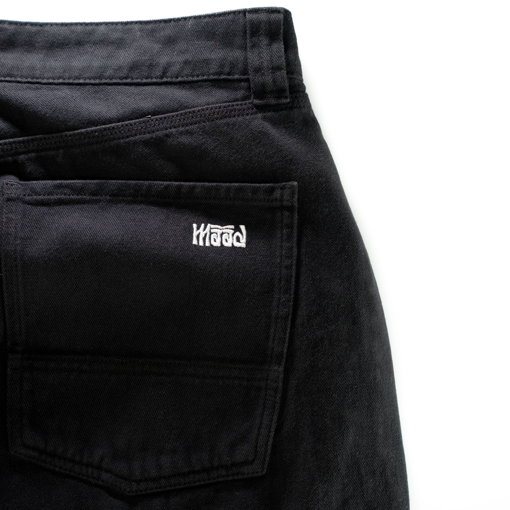 Black pants with a visible brand logo on the pocket against a white background