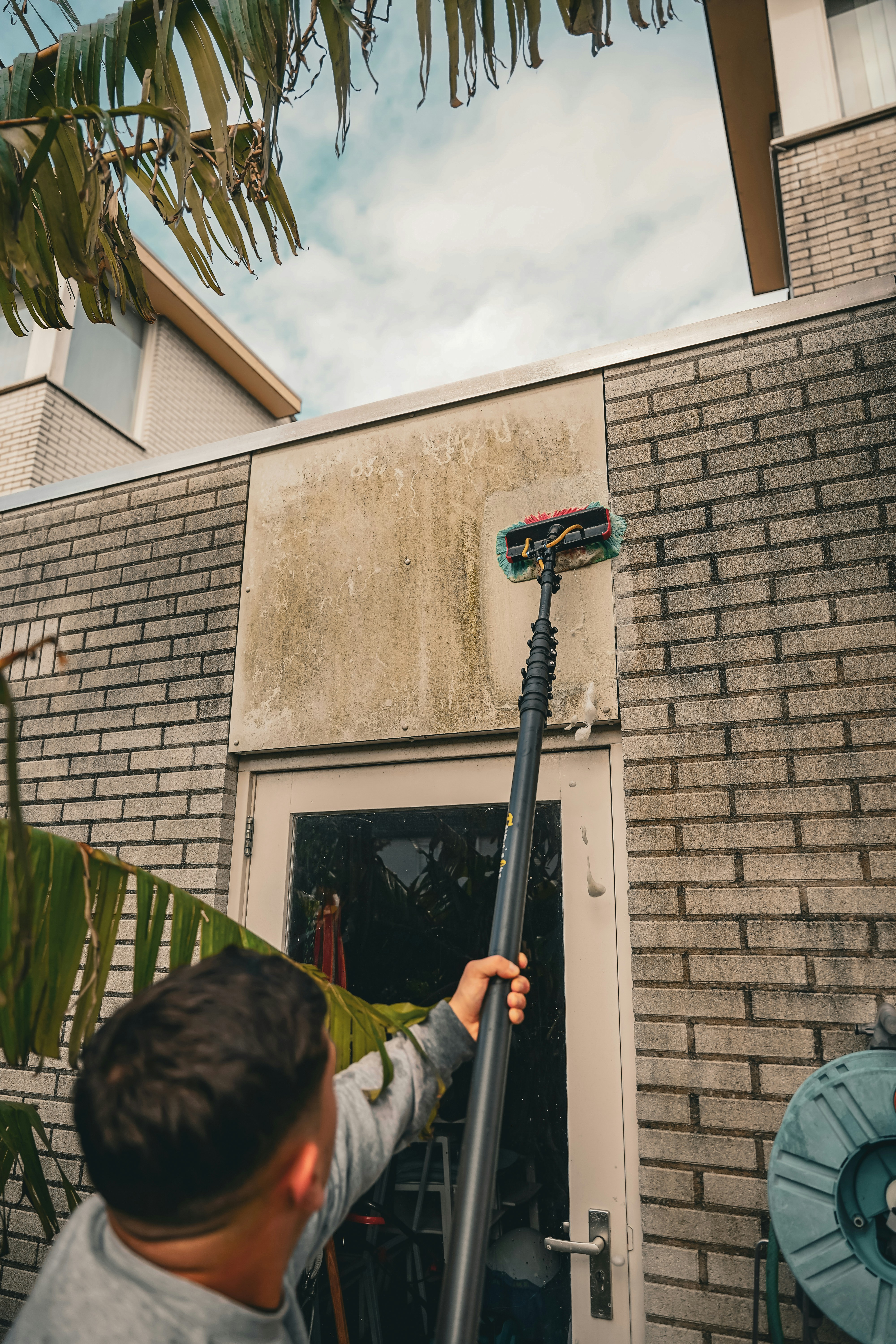 A man holding a basketball in front of a house