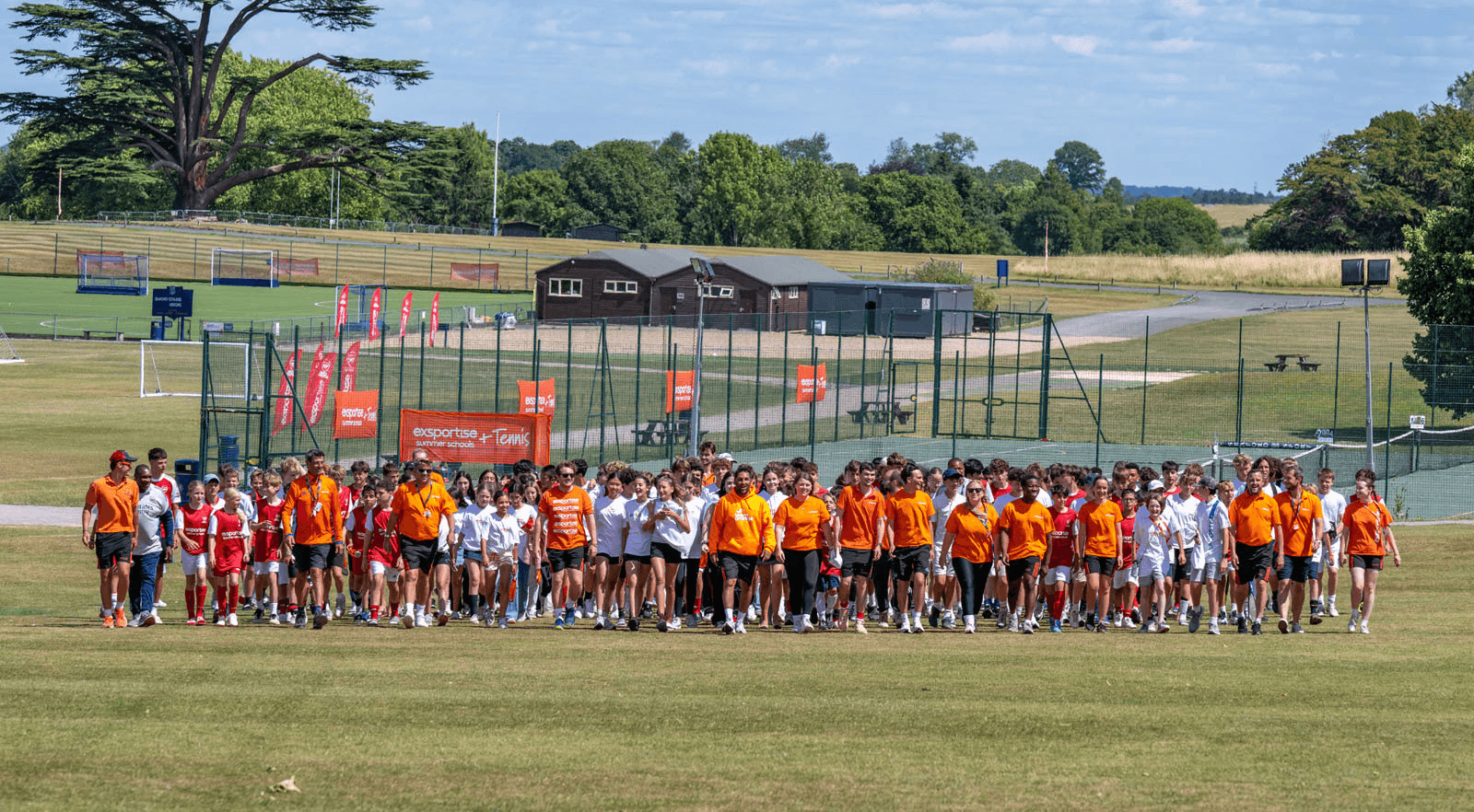 Happy campers walking as one large group from the tennis courts.
