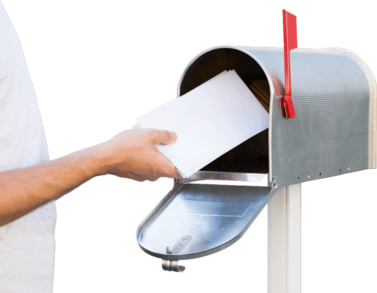 A hand placing mail inside a mailbox.
