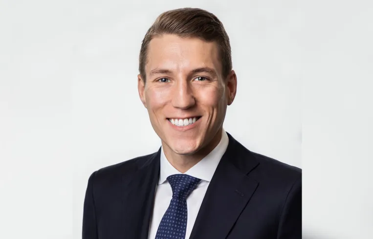 Tall modern skyscraper with vertical lines, viewed against a clear blue sky.