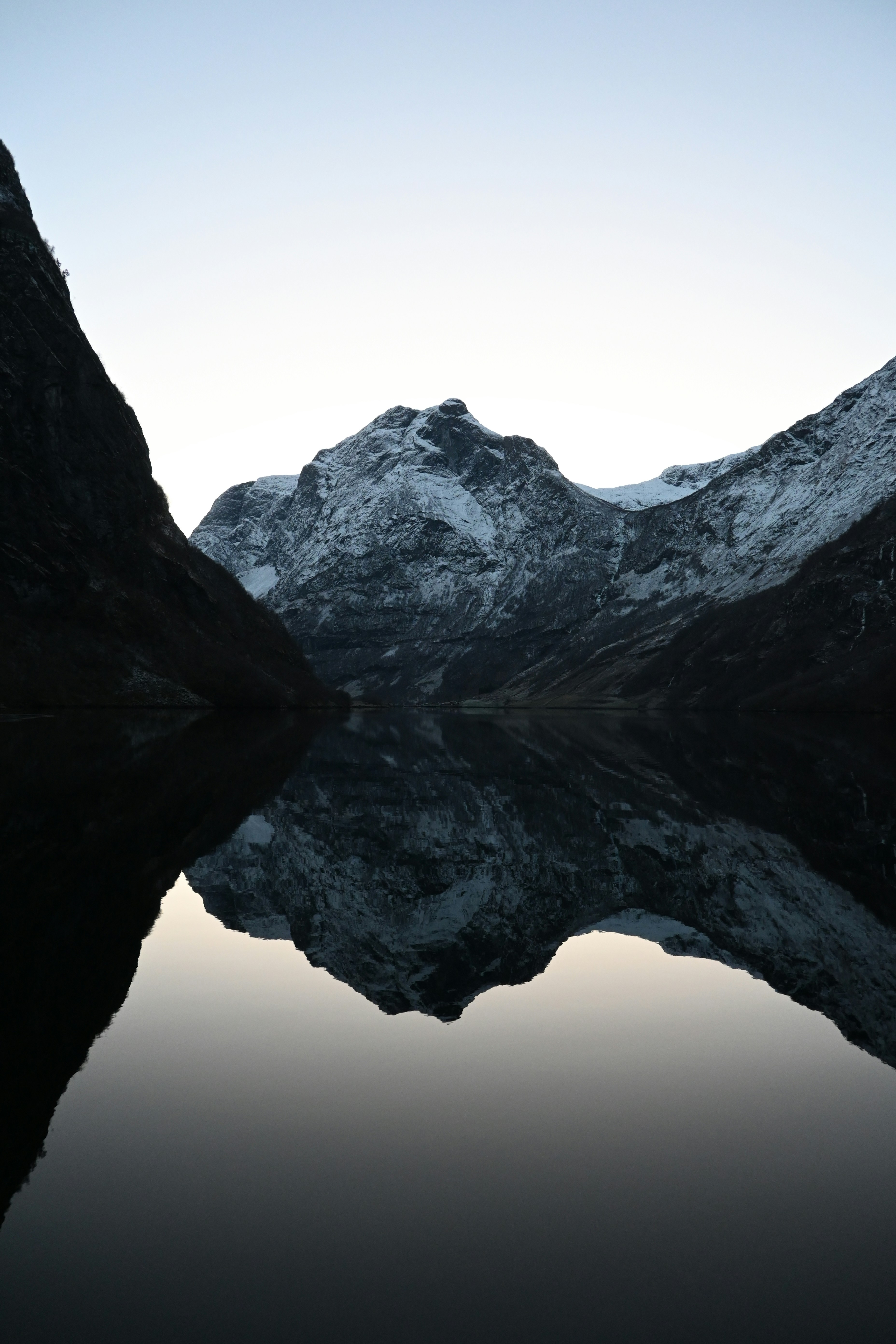 Snow-capped mountains reflected in calm water