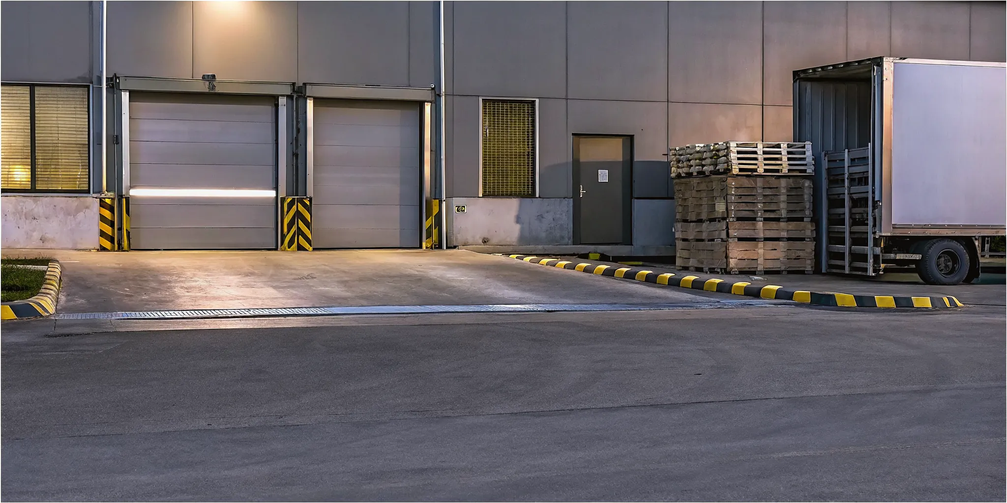Commercial loading dock with delivery truck bay and security checkpoint at an industrial facility entrance