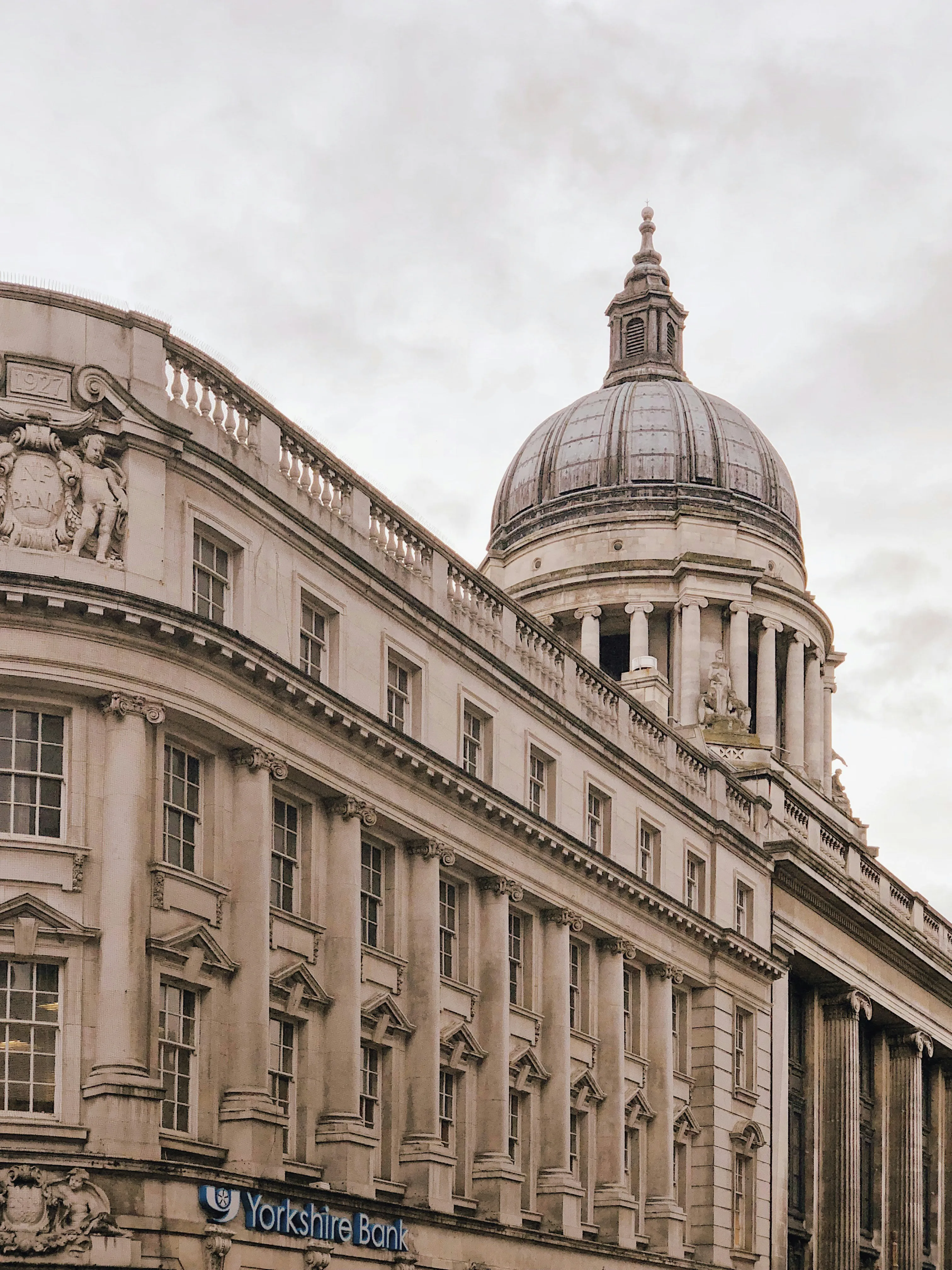 Historic building with an ornate dome, featuring classic architecture against a cloudy sky.