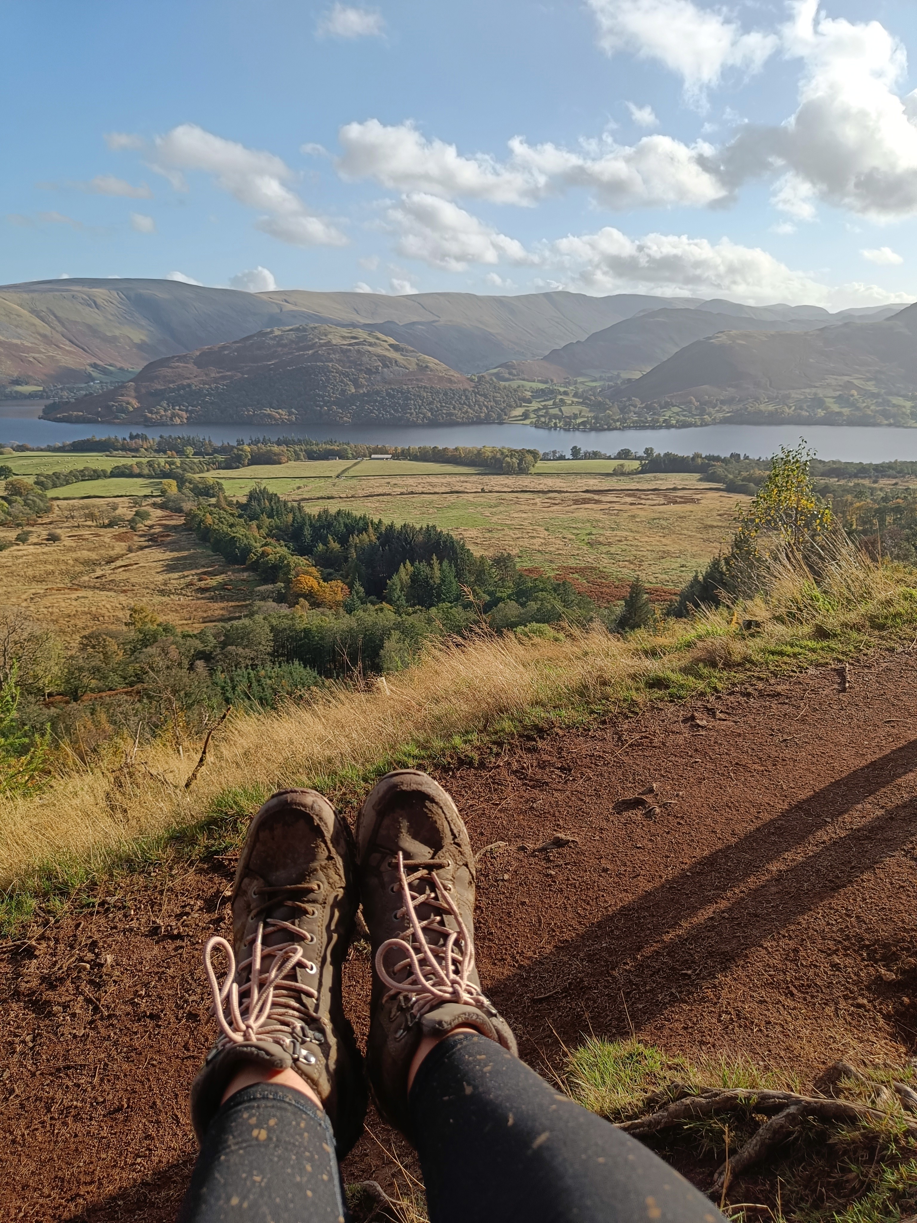 View of hiking boots overlooking rolling hills and valleys.
