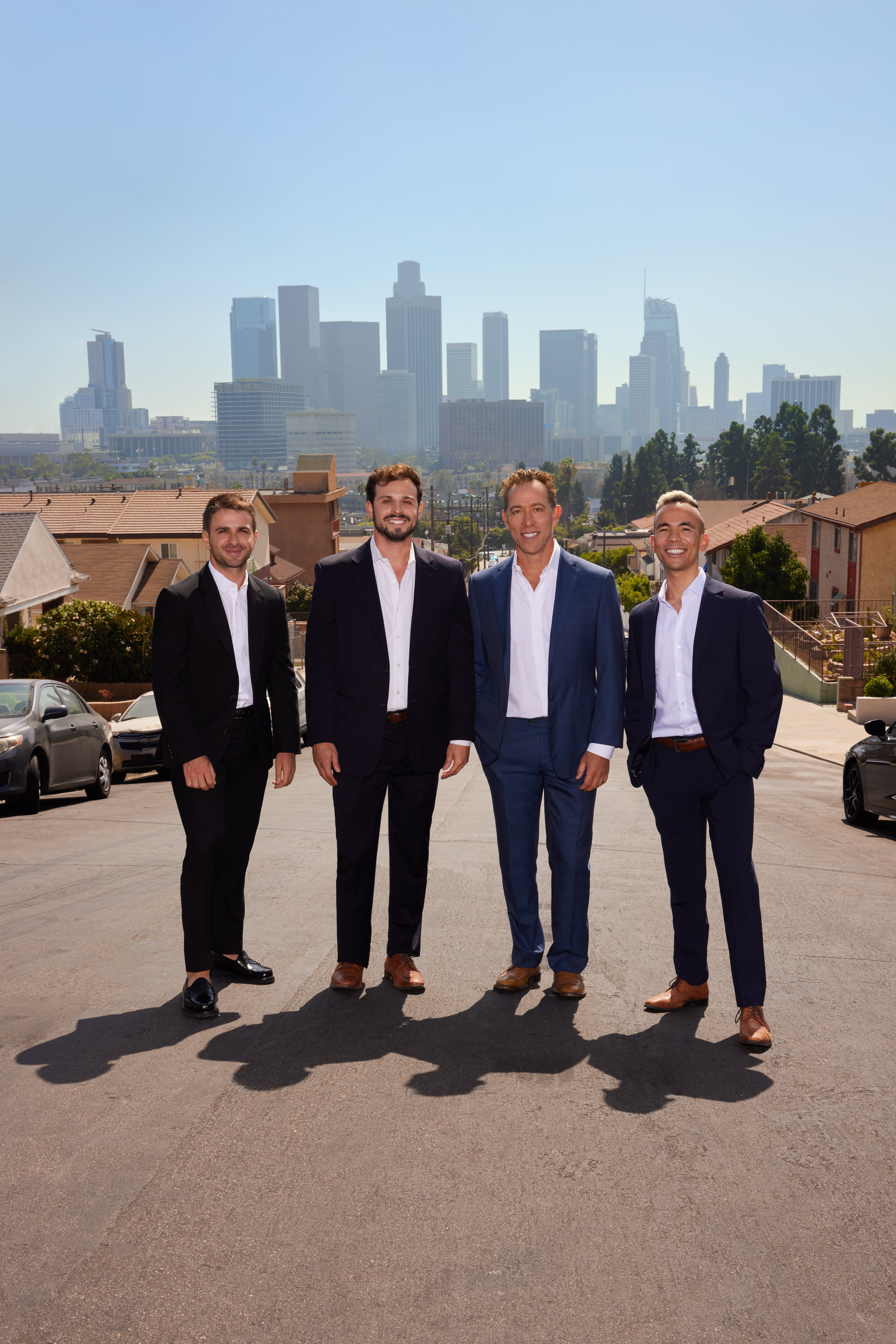 Los Angeles multifamily real estate team standing with the Downtown LA skyline behind.