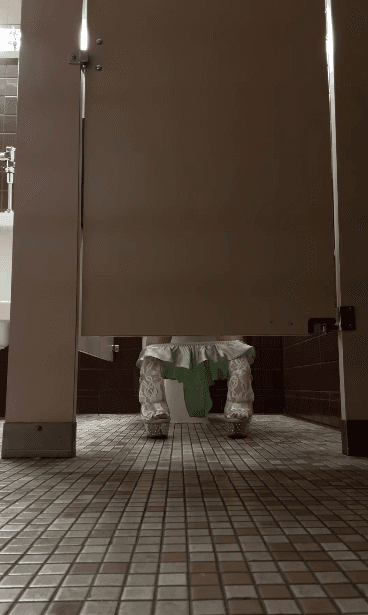 A person walks down a dimly lit alley at night.