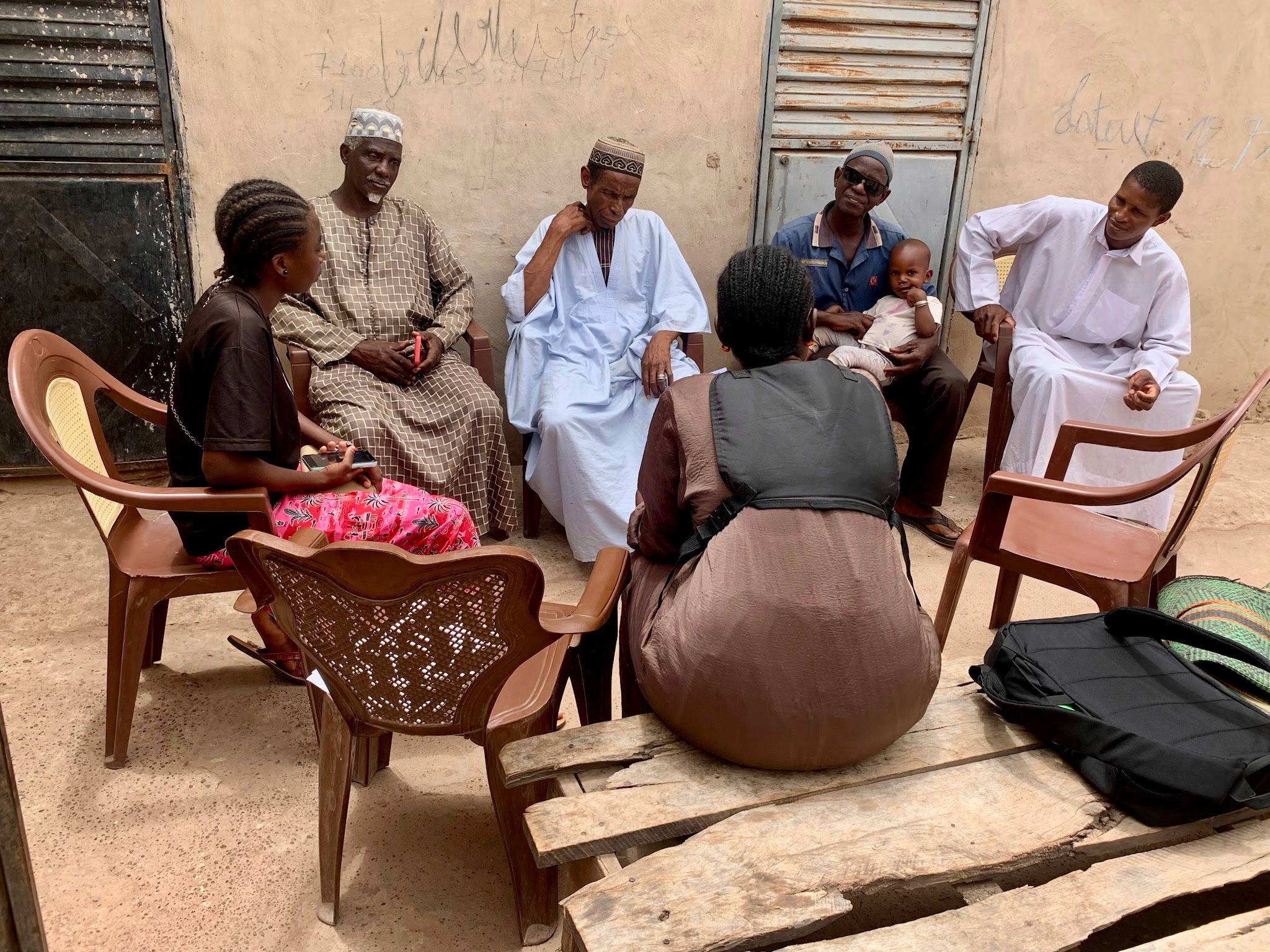 group of women in red and white dress standing on brown wooden bar during daytime