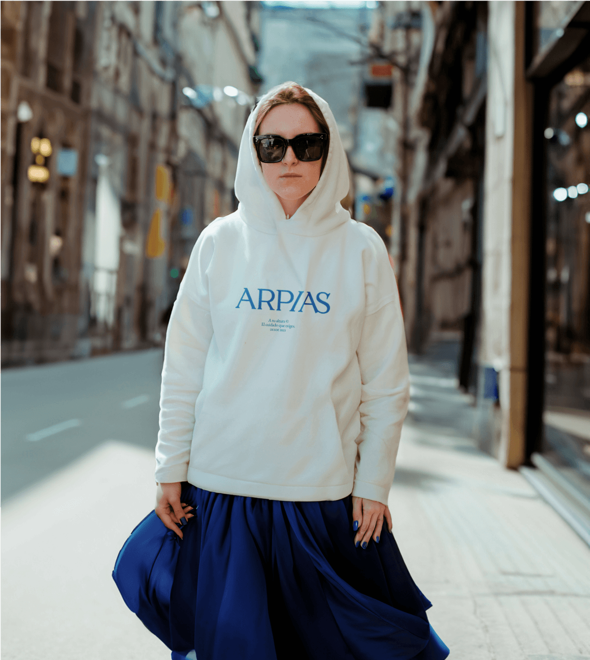 Mujer con gafas de sol vistiendo la sudadera de Arpías