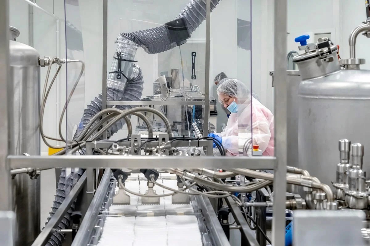 Opératrice laboratoire industriel à machine inox — photographe industriel Lille | Anteale Yann Manac’h 2025