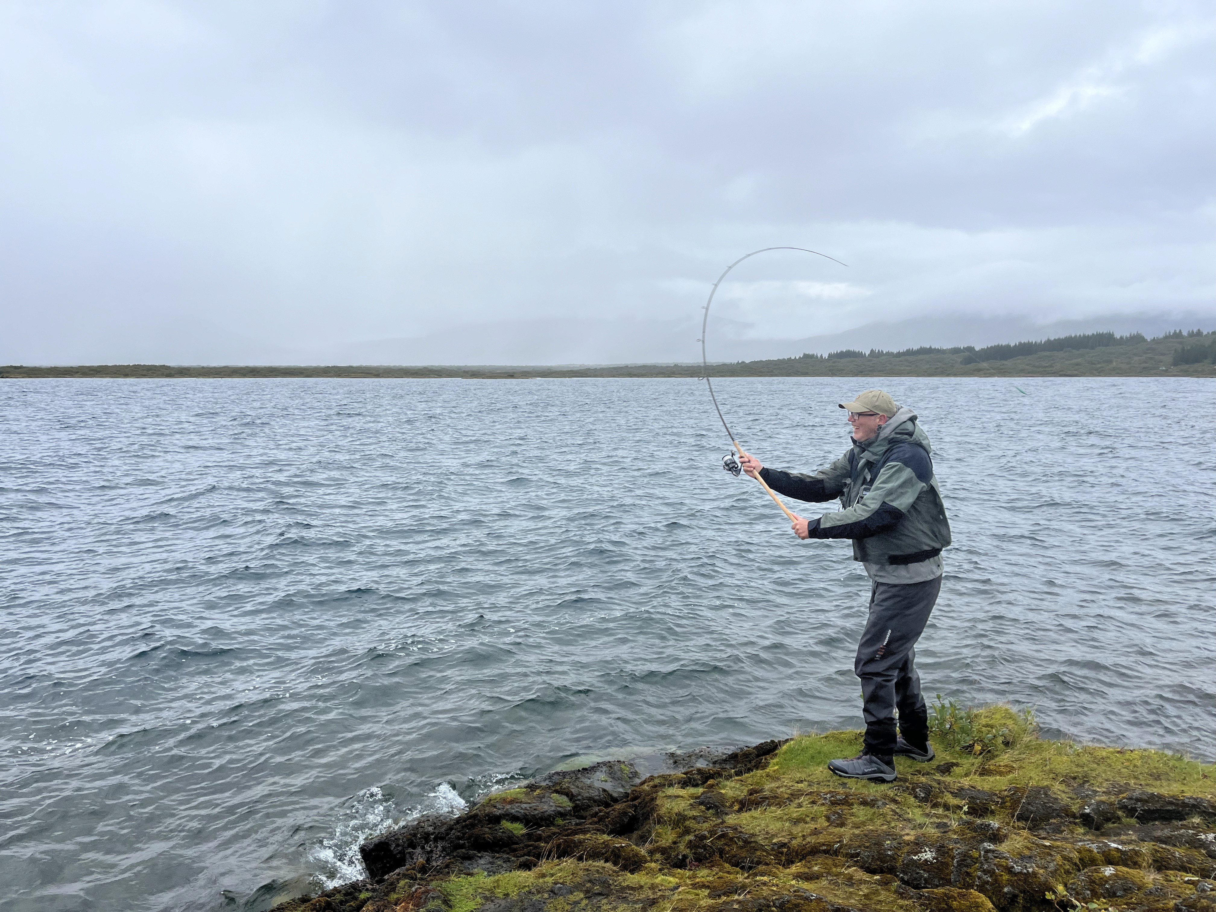 woman in blue tank top standing beside white wall
