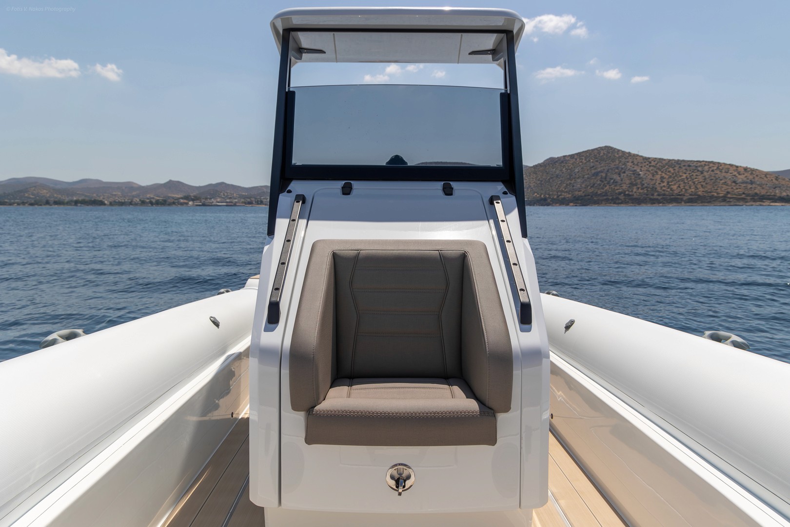 Luxury gray leather seating with quilted backrest and built-in storage compartment in yacht interior cabin.