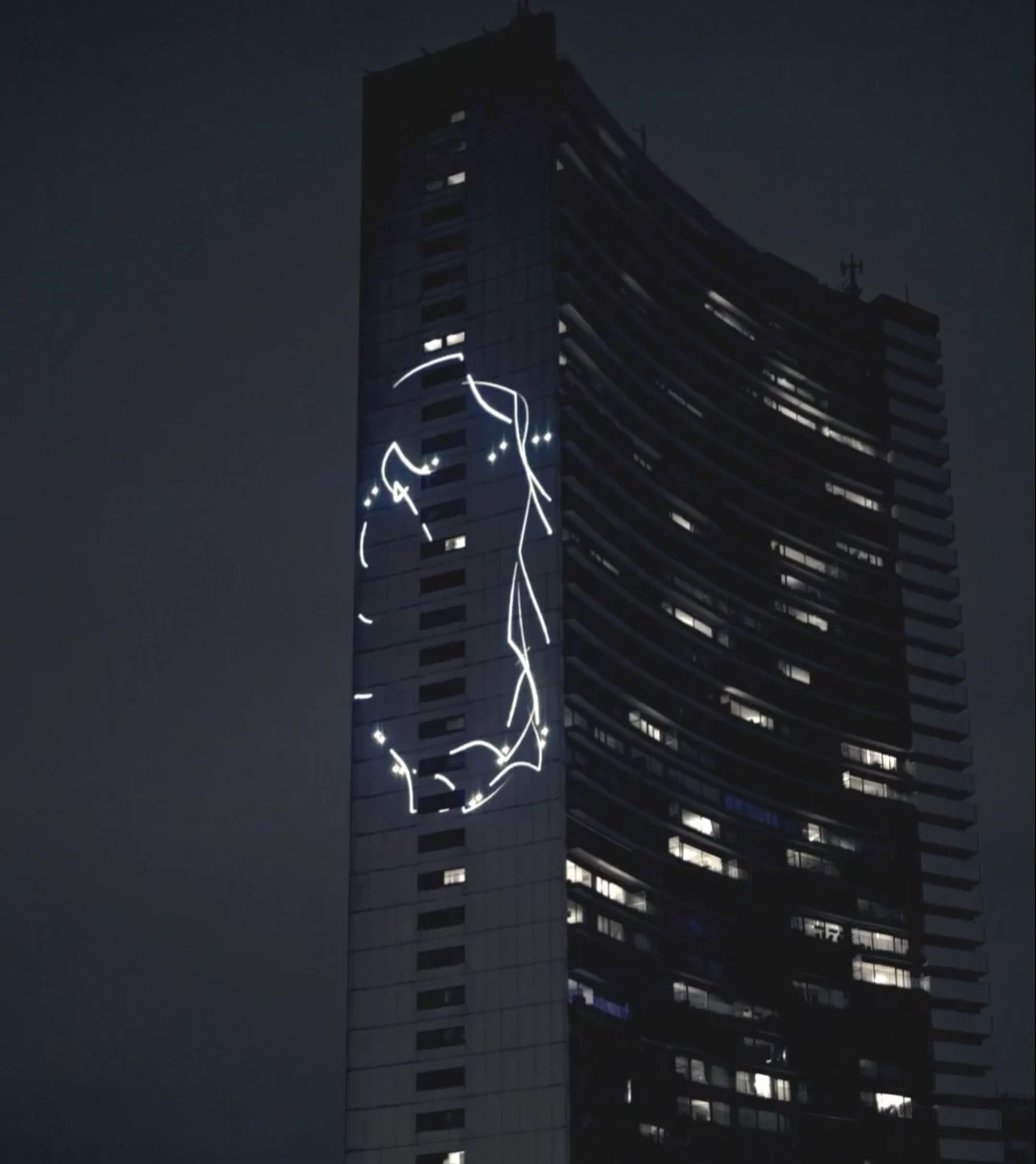 Building with light projection of a face