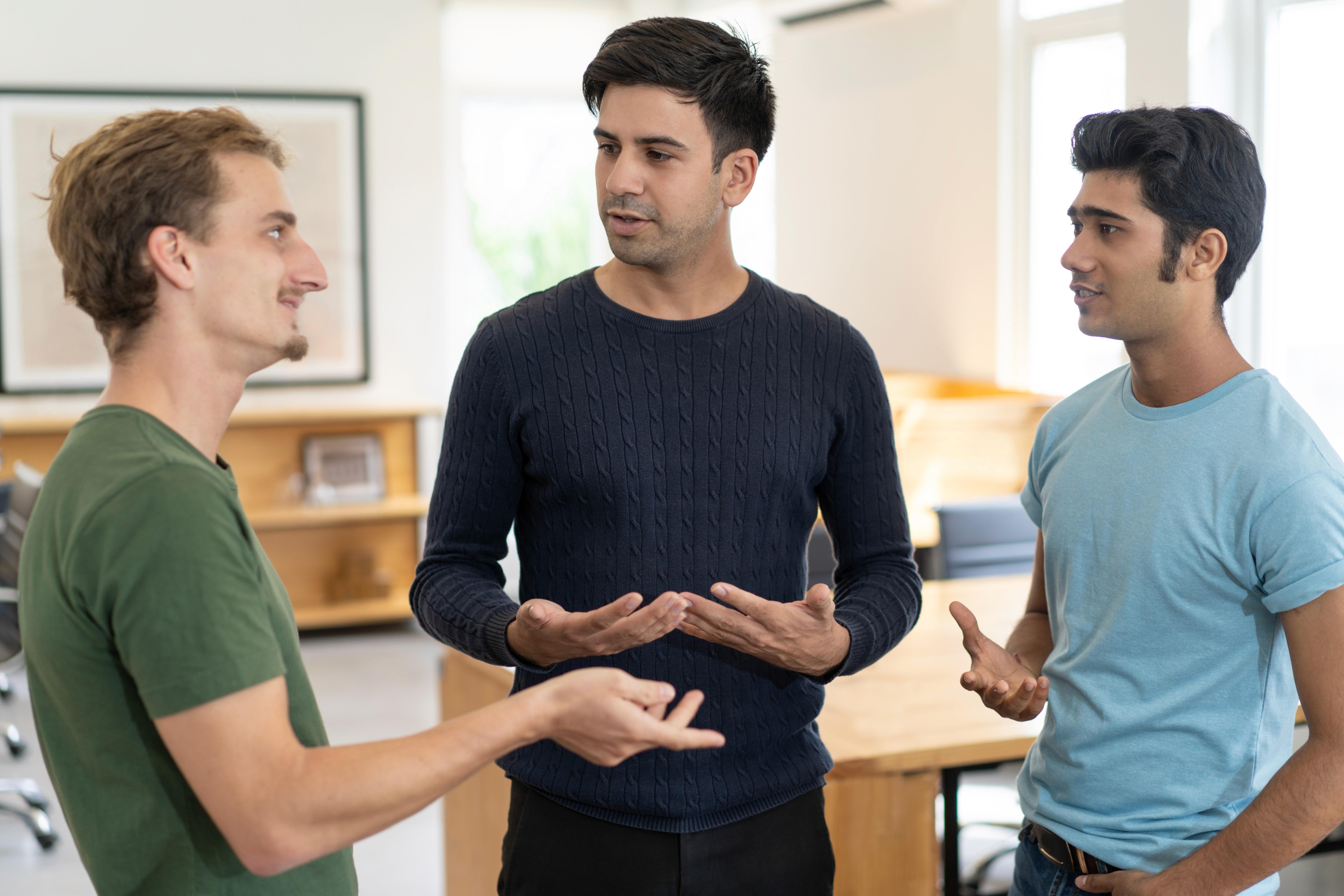 Coworkers using open body language during conversation at work