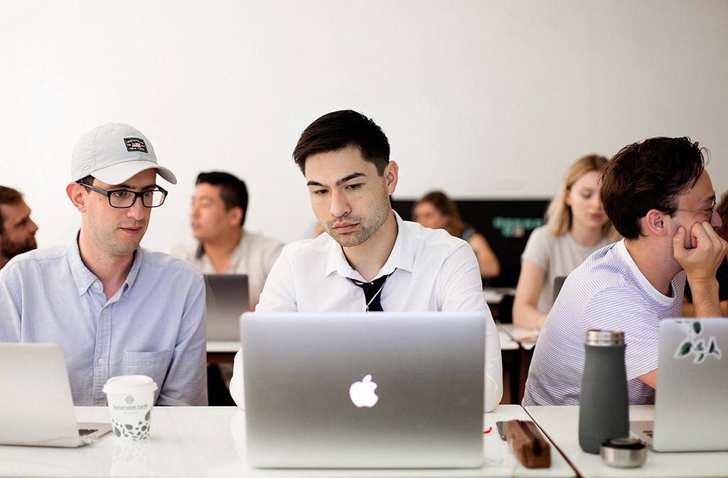  designer working thoughtfully at a desk, laptop open, deep in a design challenge.