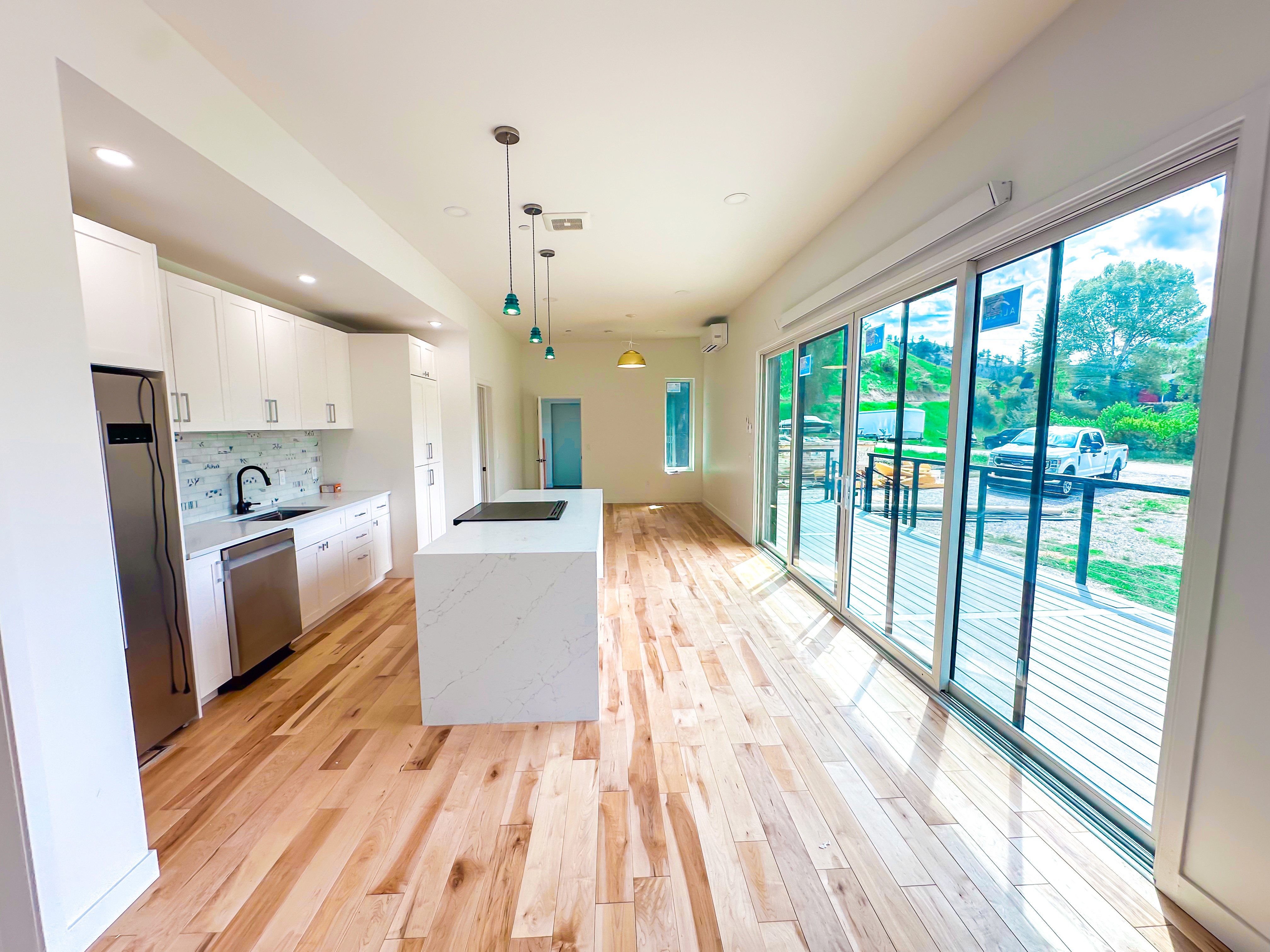 A beautiful kitchen with large pannel windows overlooking a lush forest.