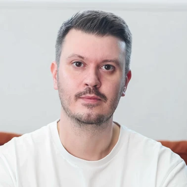 Man in white t-shirt with short hair.