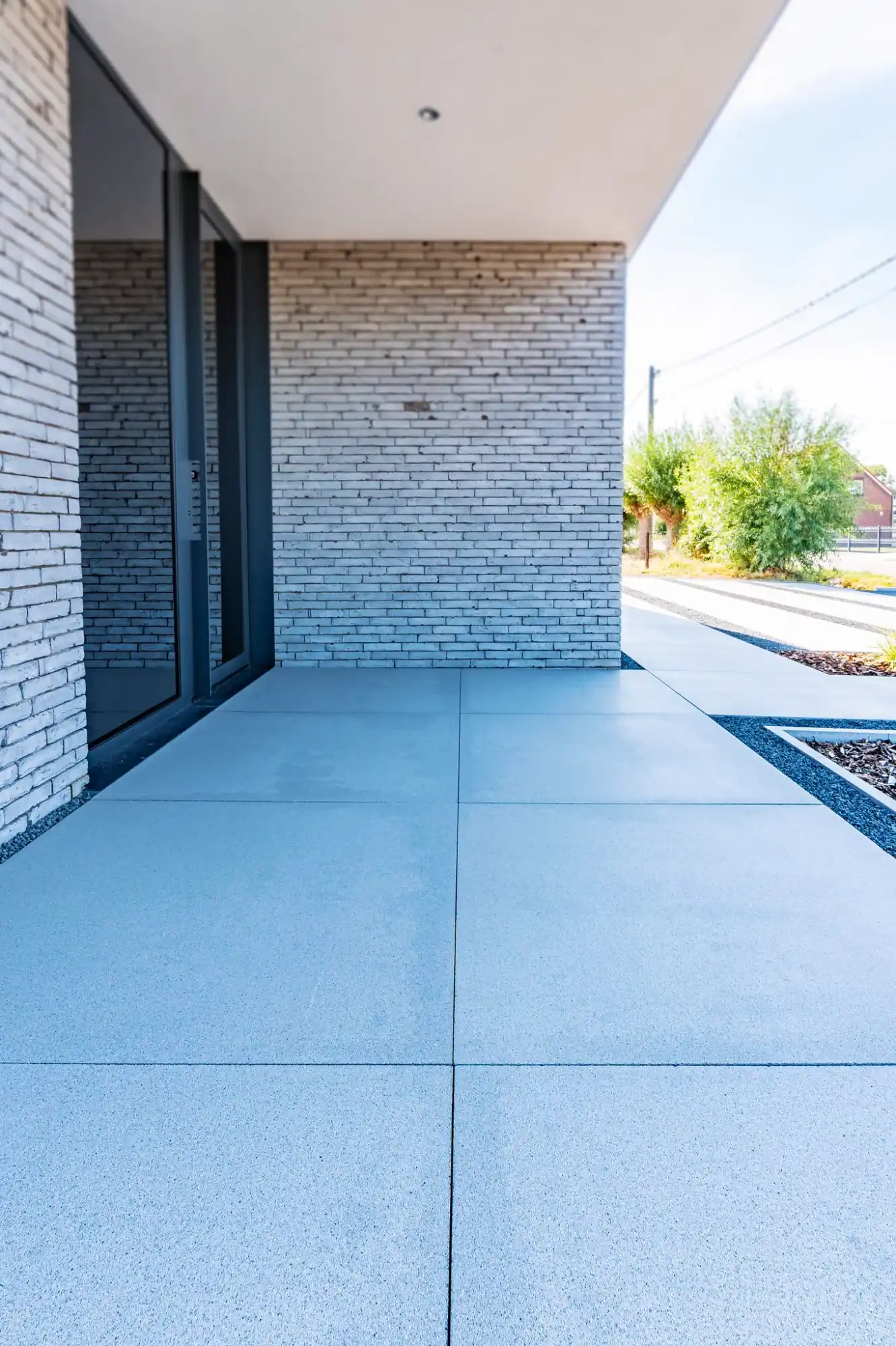 Aanleg betontegels voor waterdoorlatende verharding.