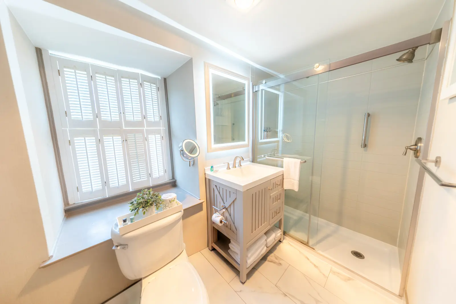 Bathroom interior with shower, sink, toilet and window.
