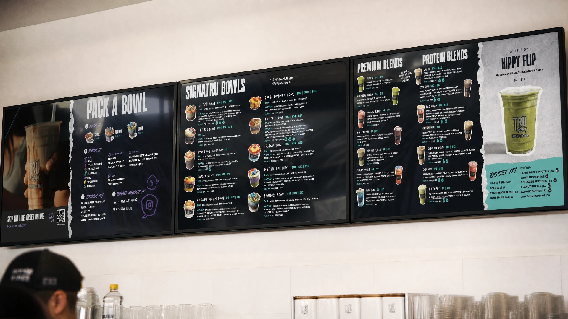 Three digital menu designs over top of a counterm, showing smoothies and superfood bowls