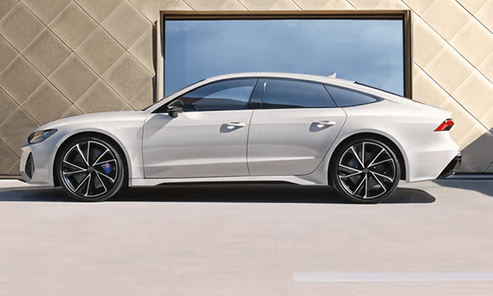 White Audi A7 parked in front of a modern building. Luxury sedan.