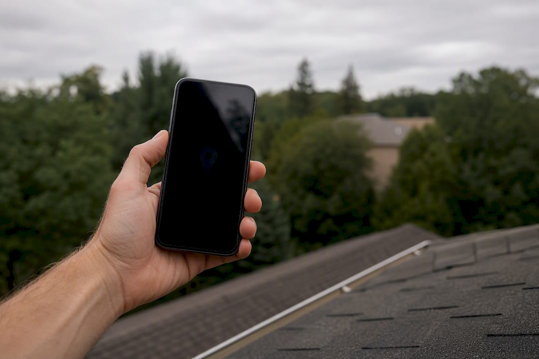 Hand holding smartphone outdoors