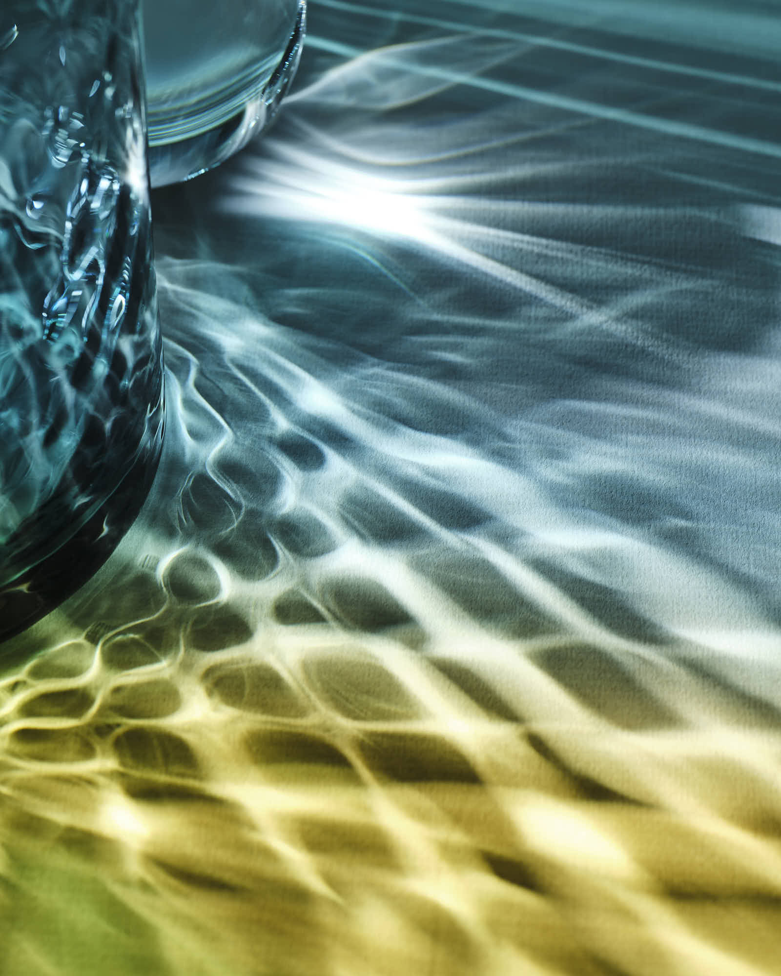 Abstract light reflections on textured surface with blue and gold hues.