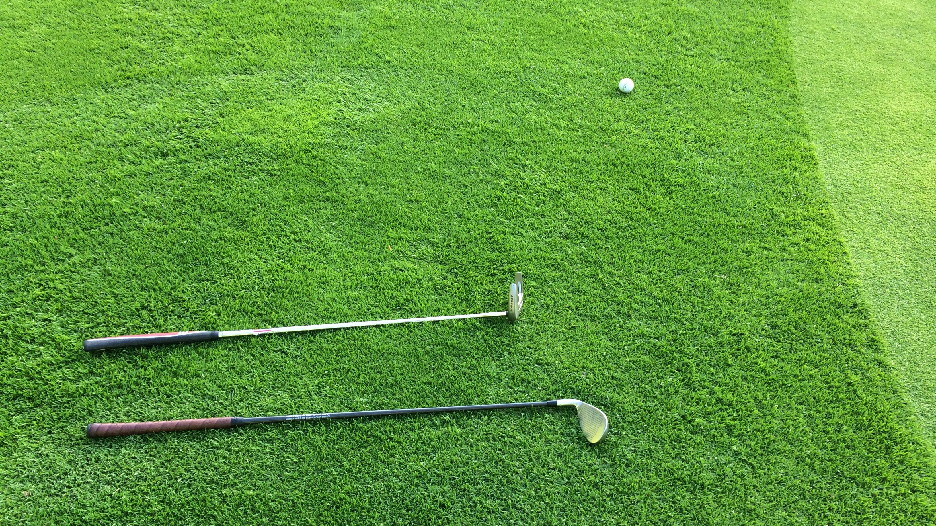 two golf clubs on green grass field