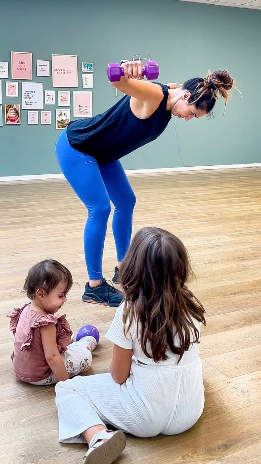 Maman faisant une séance de renforcement musculaire avec sa fille et son bébé