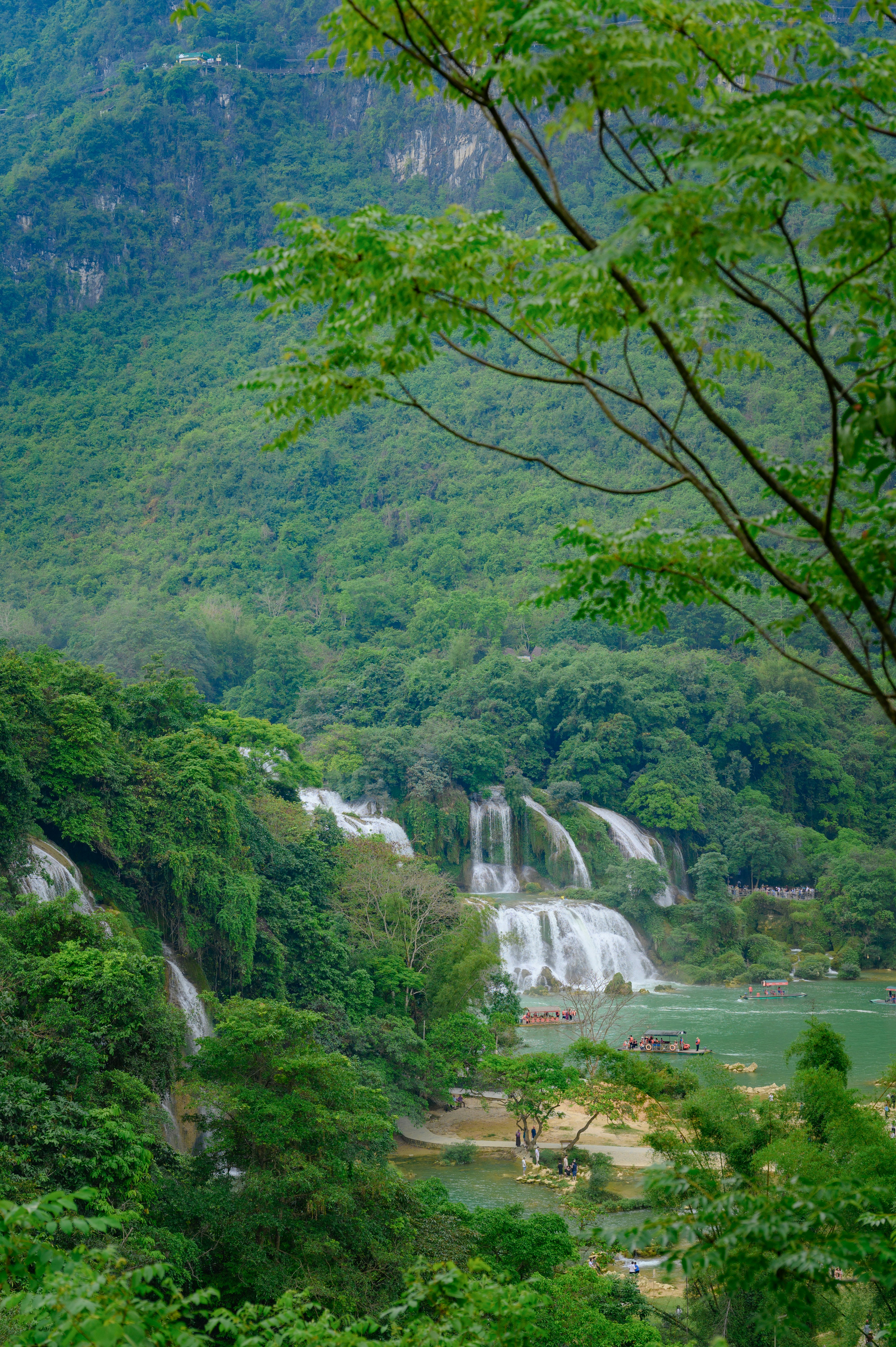Lush green mountains with a cascading waterfall and turquoise water
