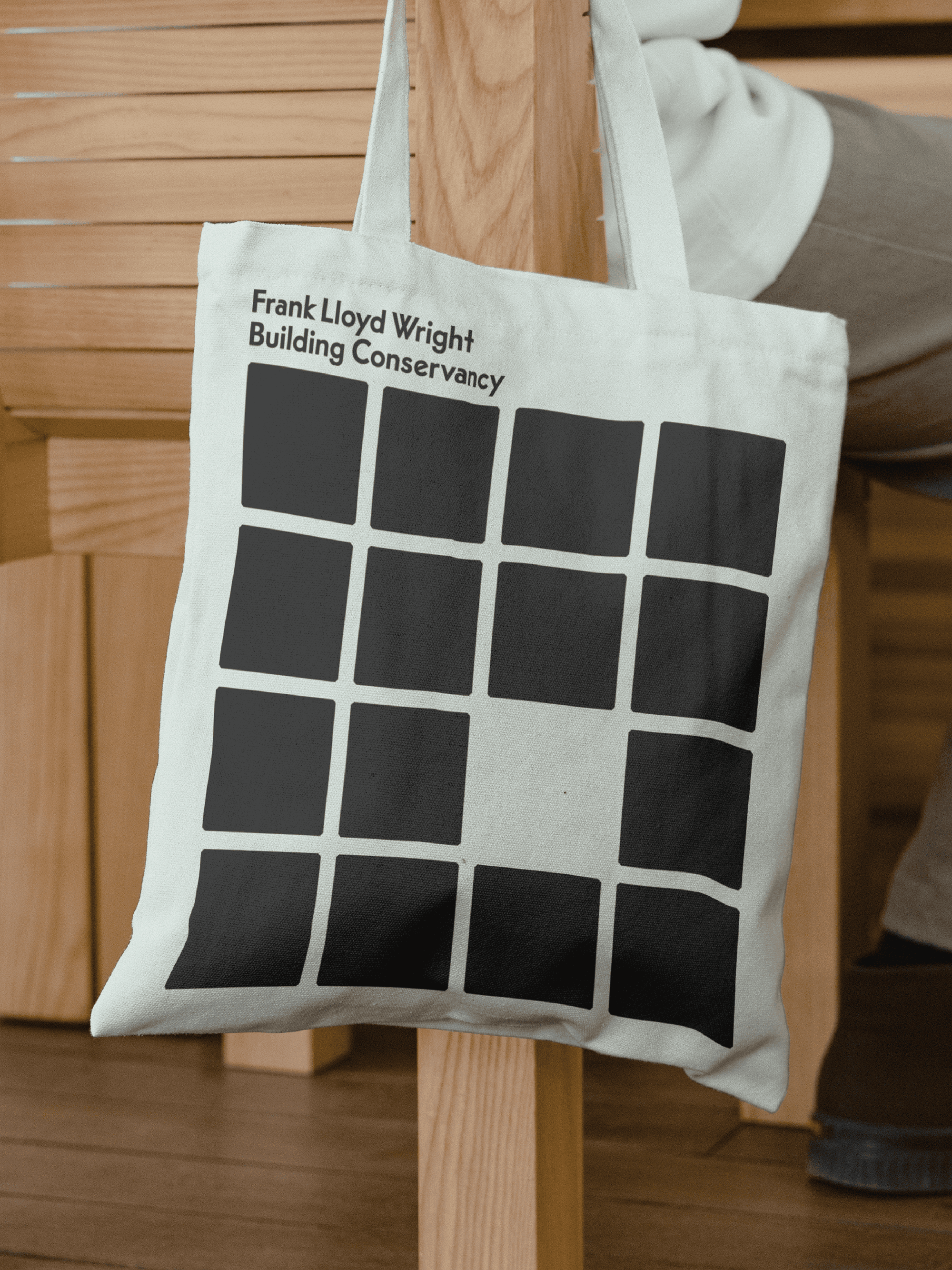 A tote bag with a series of black squares printed on