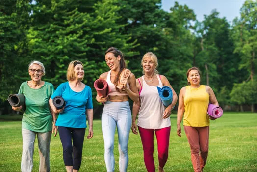 group of women holding yoga mats