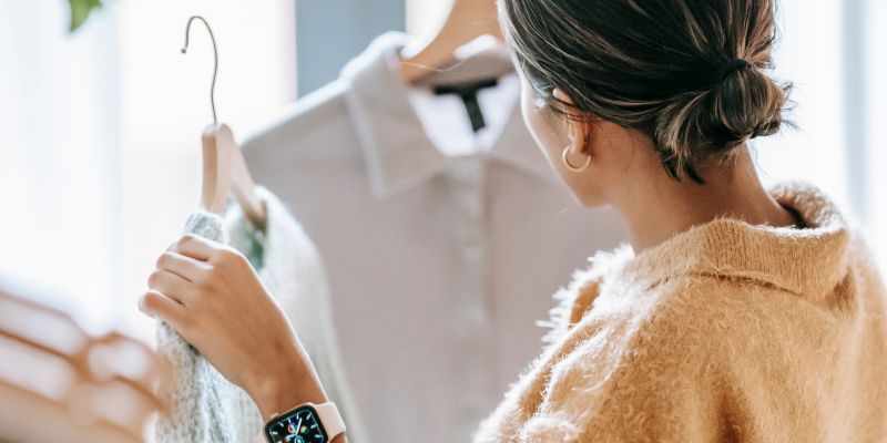 A retail staff arranging clothes in a retail store