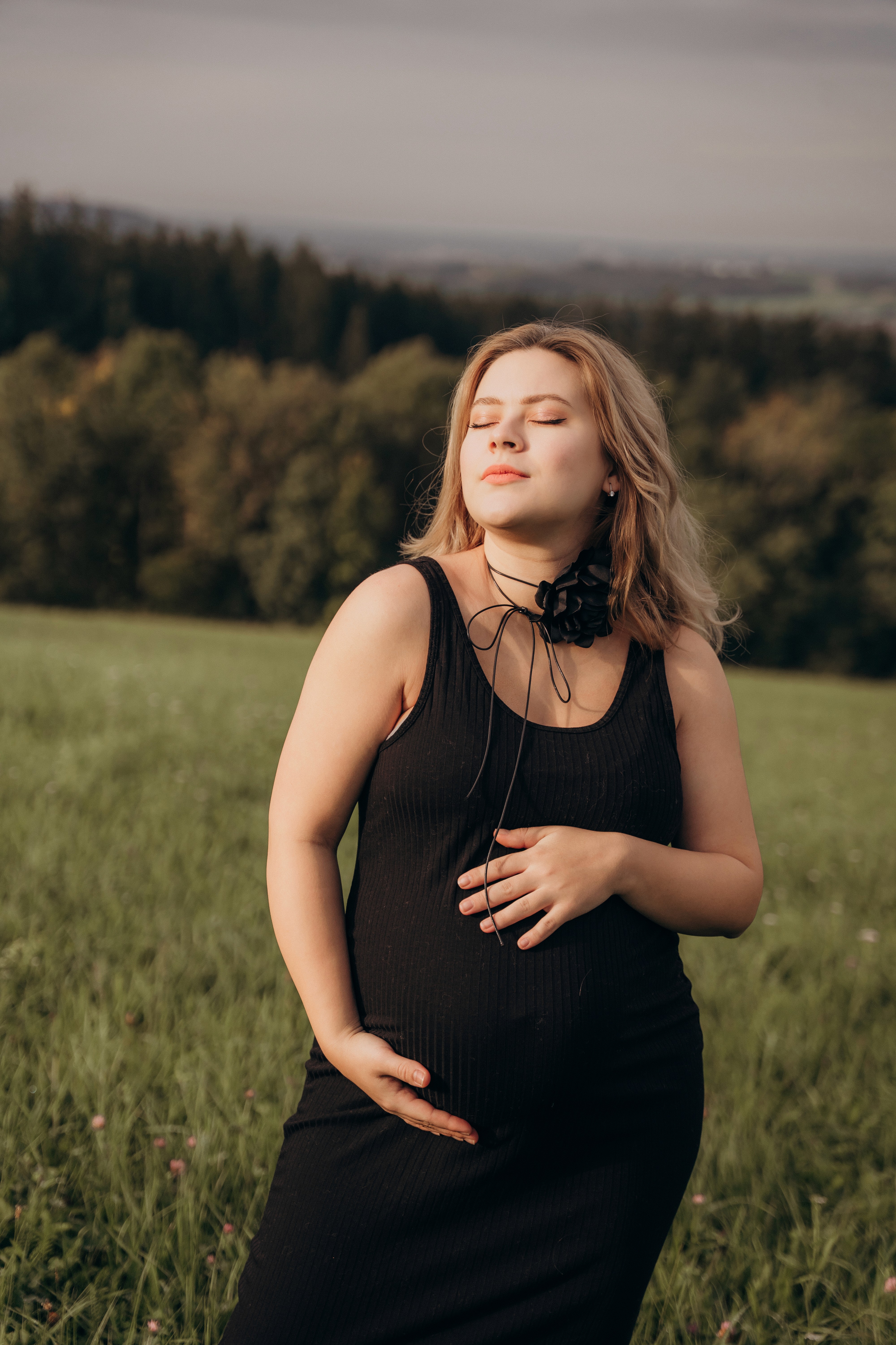 Schwangerschaftsfotografie in Bogen, Bayern – werdende Mutter im schwarzen Kleid bei natürlichem Outdoor Shooting.