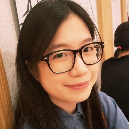 photo portrait of a smiling woman, with long dark hair and glasses