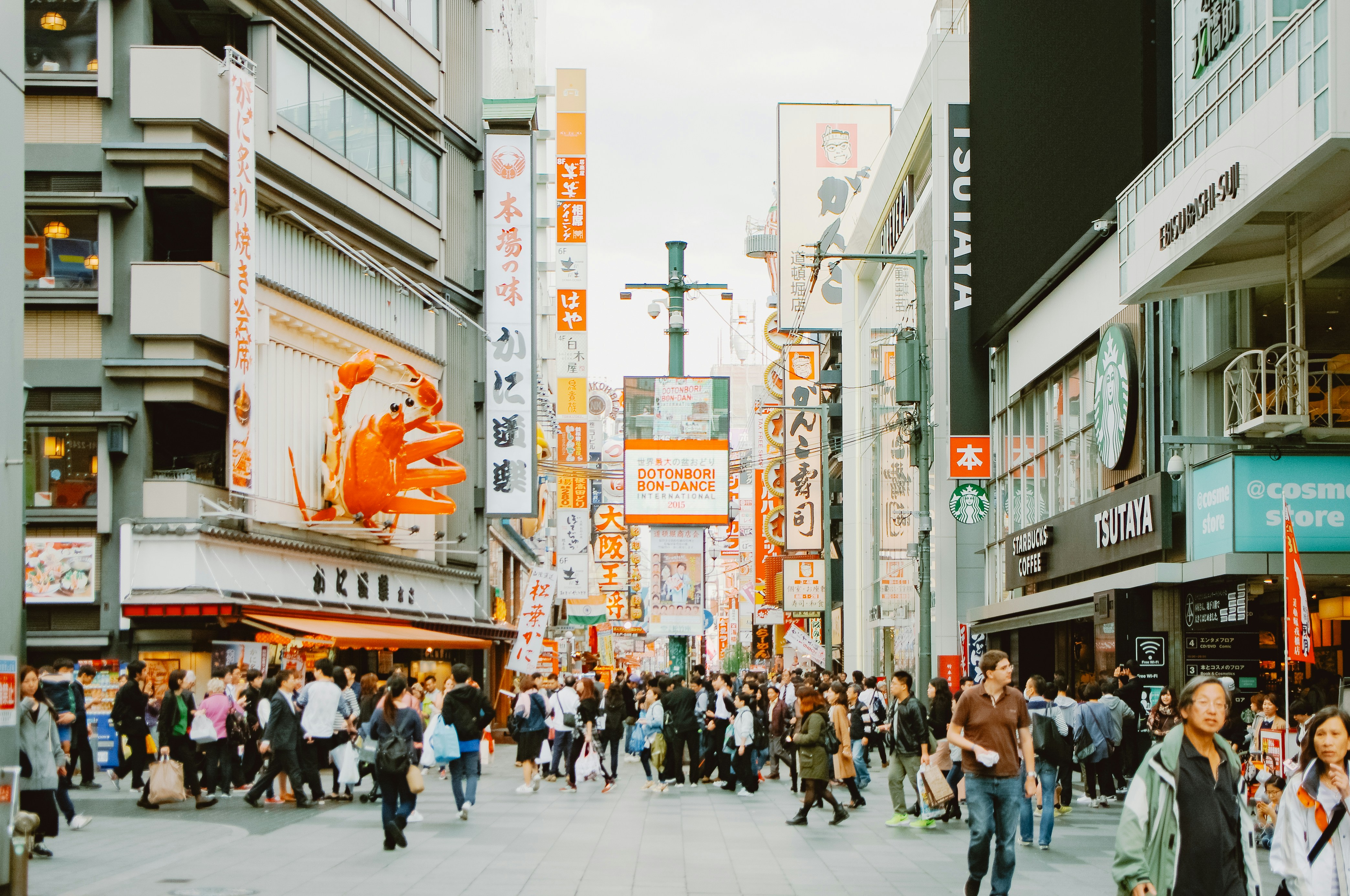 Crowded street scene in a japanese city with neon signs.