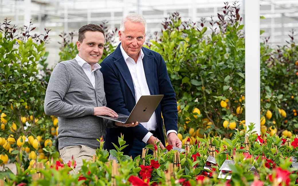 Rene en Robin met een laptop bij de kweker
